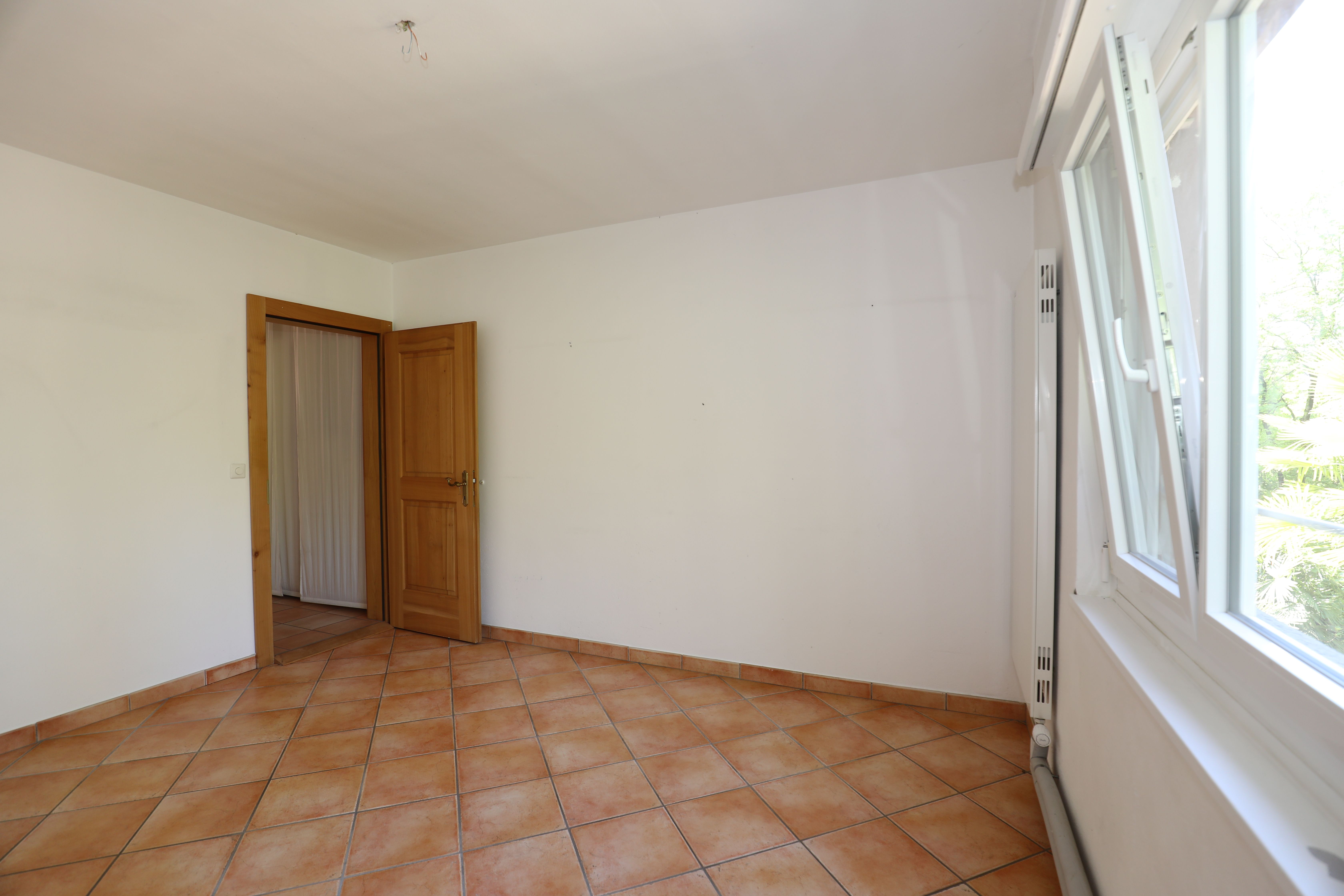 Leerer Raum mit Fliesenboden und Fenster