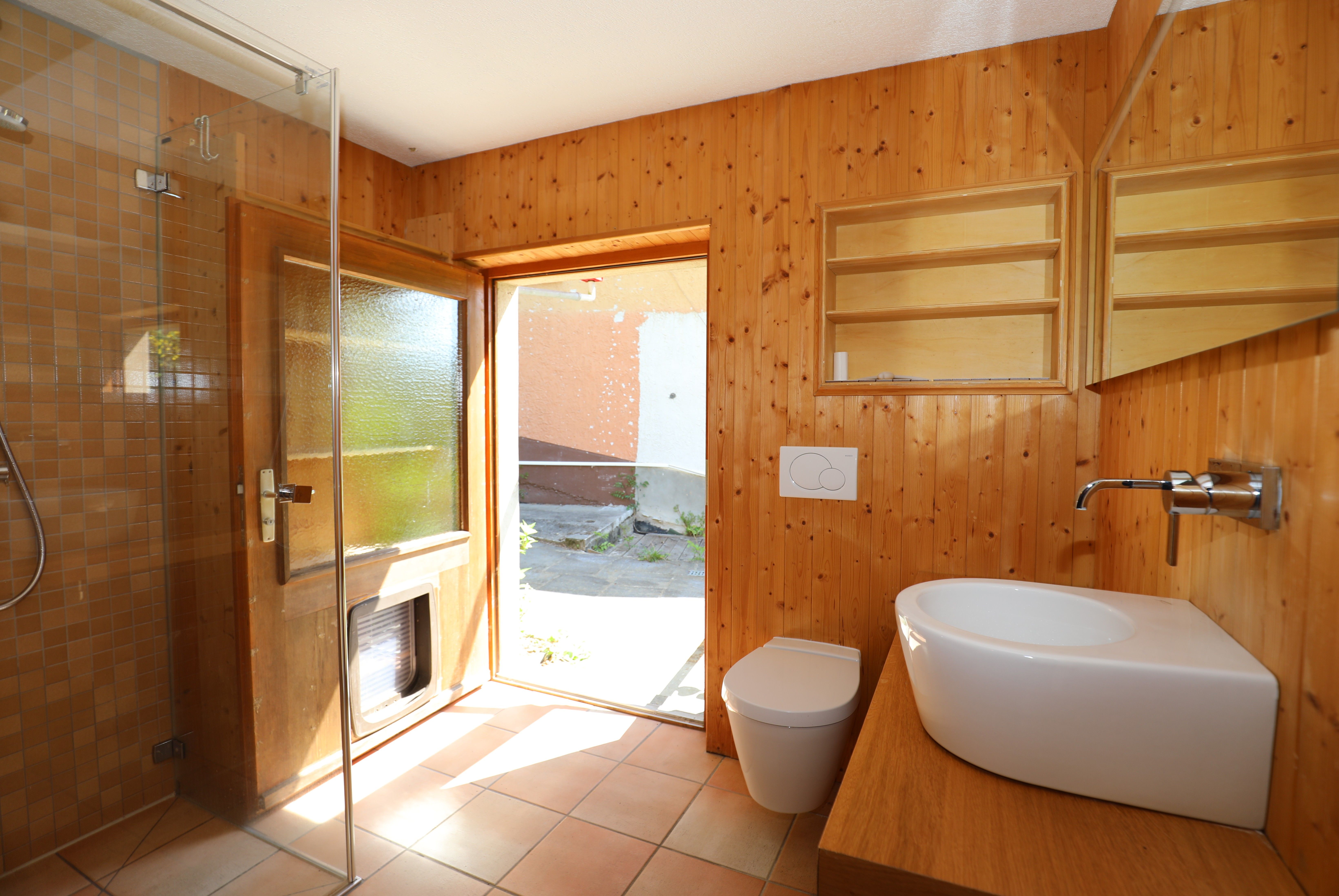 Holzvertäuschtes Badezimmer mit Dusche und Waschbecken