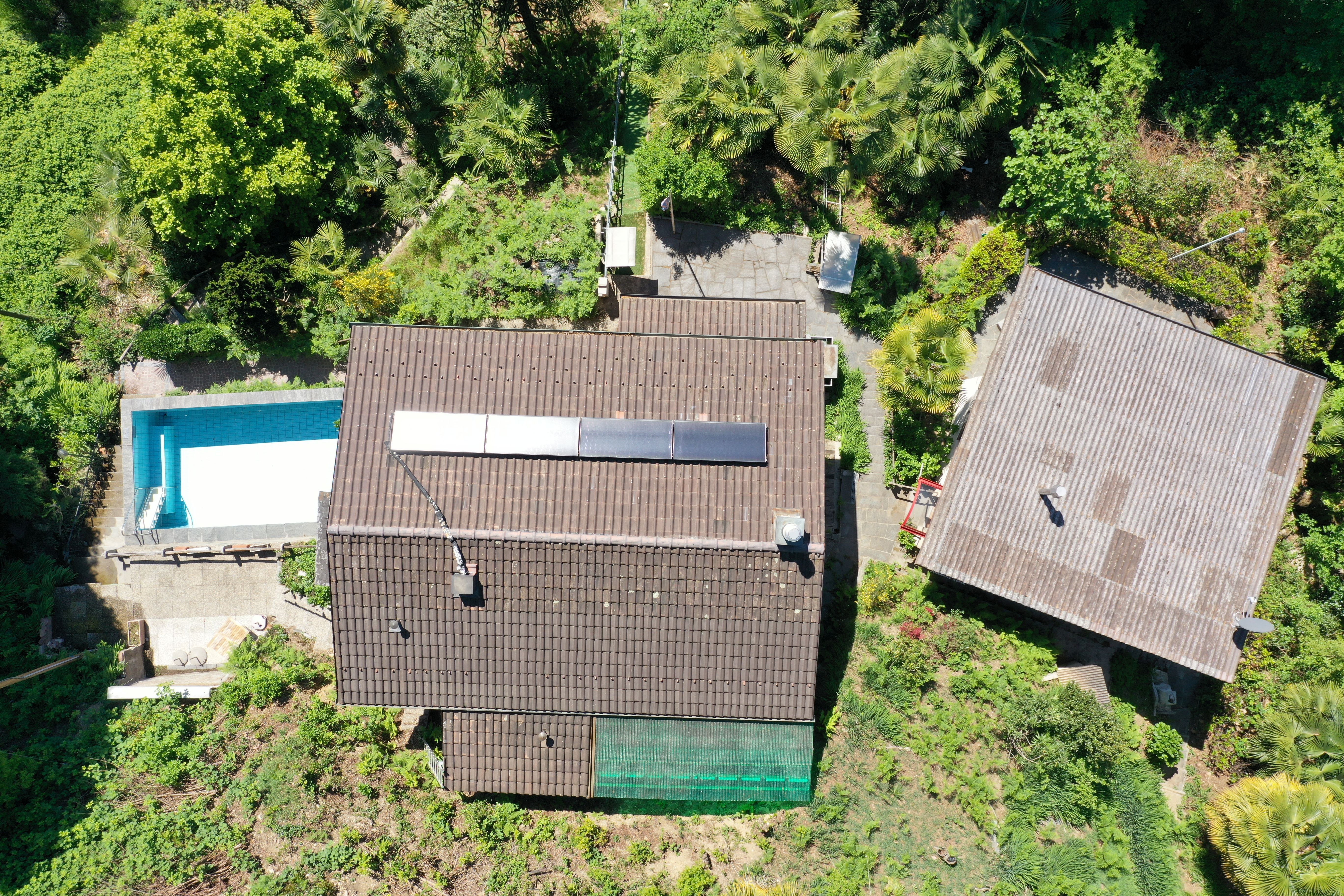 Luftaufnahme eines Wohnhauses mit Pool und üppigem Garten