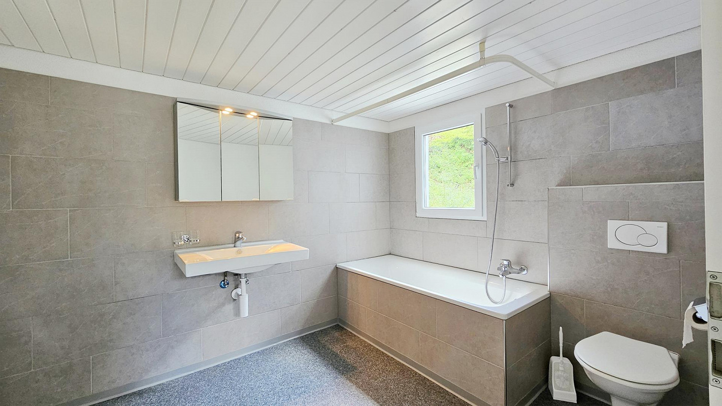 Modernes Badezimmer mit Wanne und Fenster
