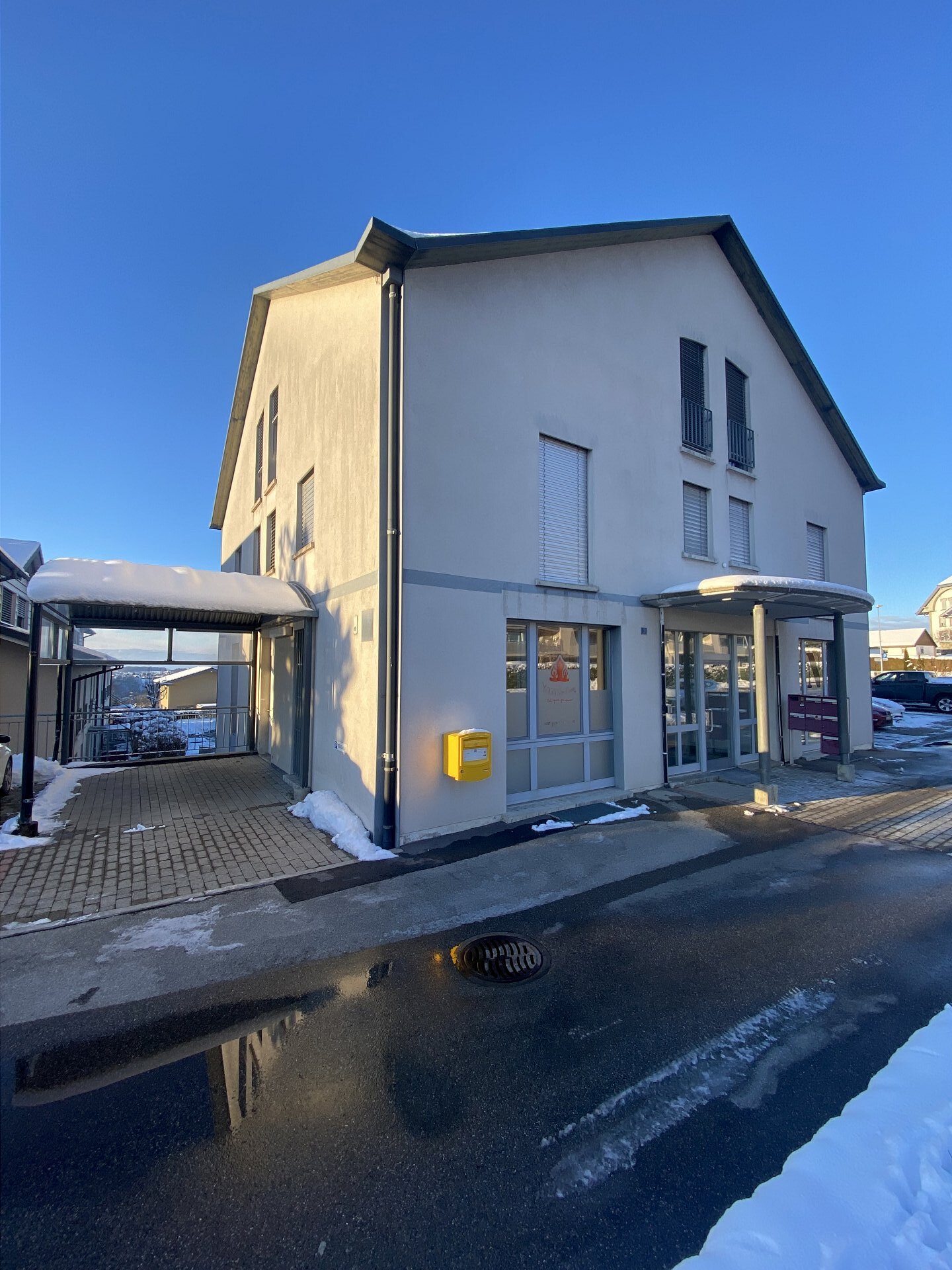Mehrfamilienhaus mit verputzter Fassade im Schnee