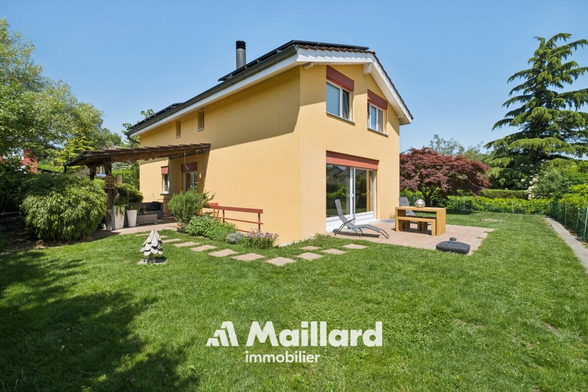 Gelbes Einfamilienhaus mit großem Garten