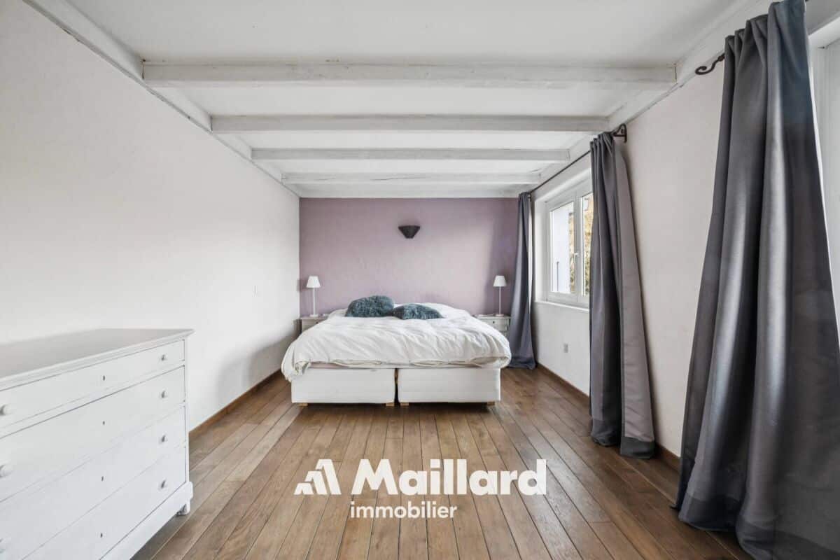 Schlafzimmer mit Holzboden und sichtbaren Deckenbalken