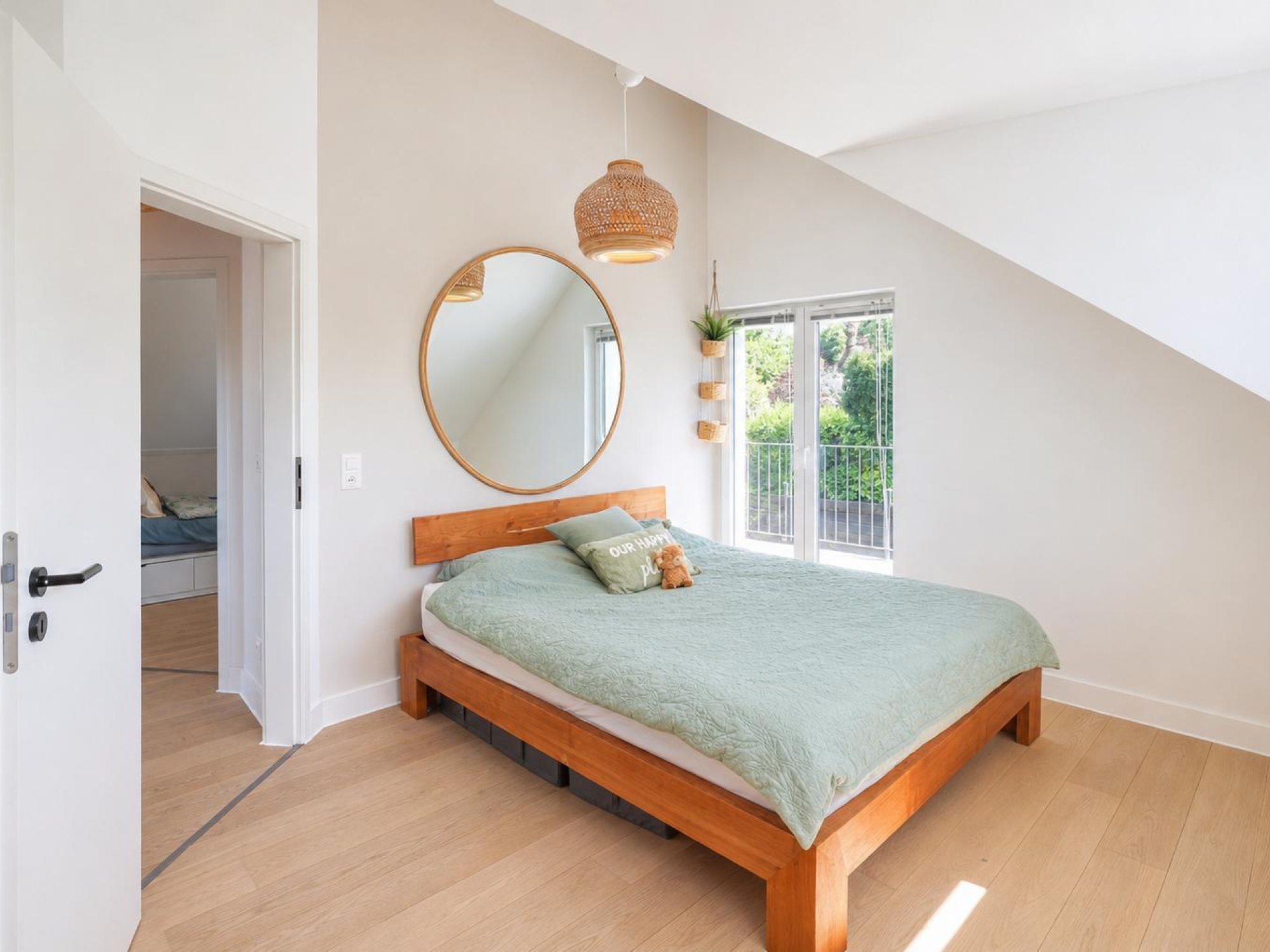 Helles Schlafzimmer mit Holzbett und Dachschräge