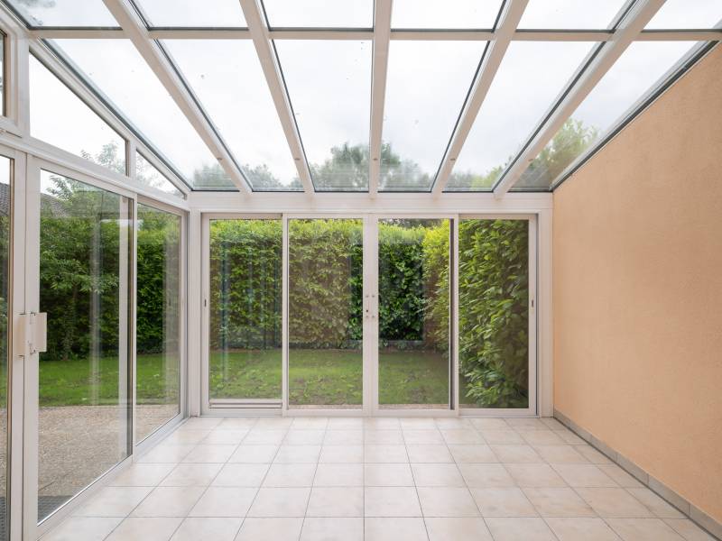 Wintergarten mit Glasdach und Blick in den Garten
