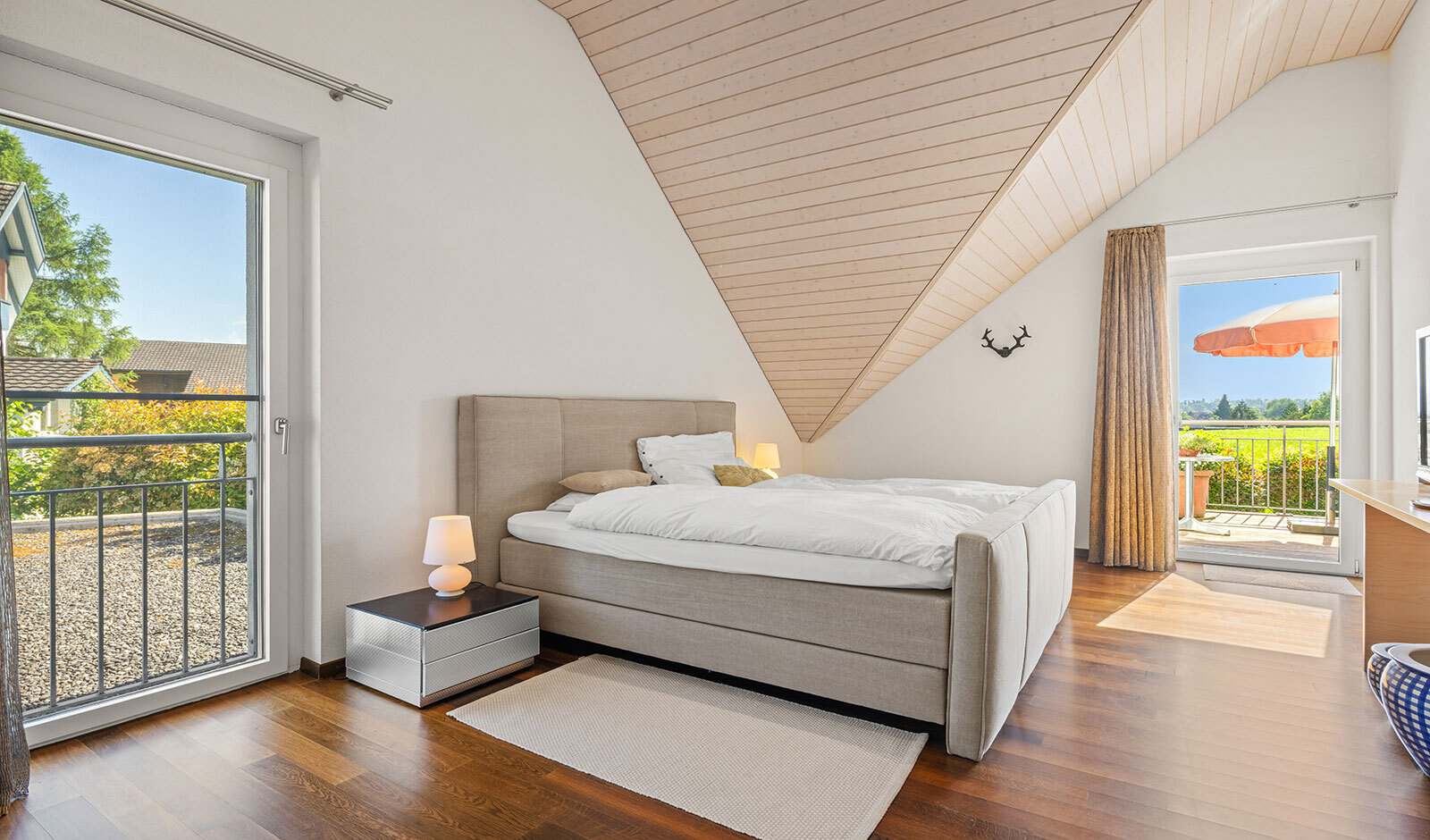 Helles Schlafzimmer mit Dachschräge und Balkonzugang