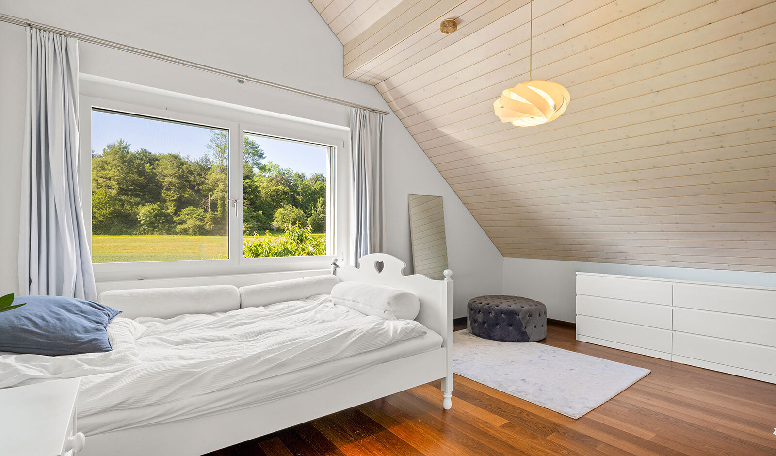 Helles Dachgeschoss-Schlafzimmer mit Blick ins Grüne