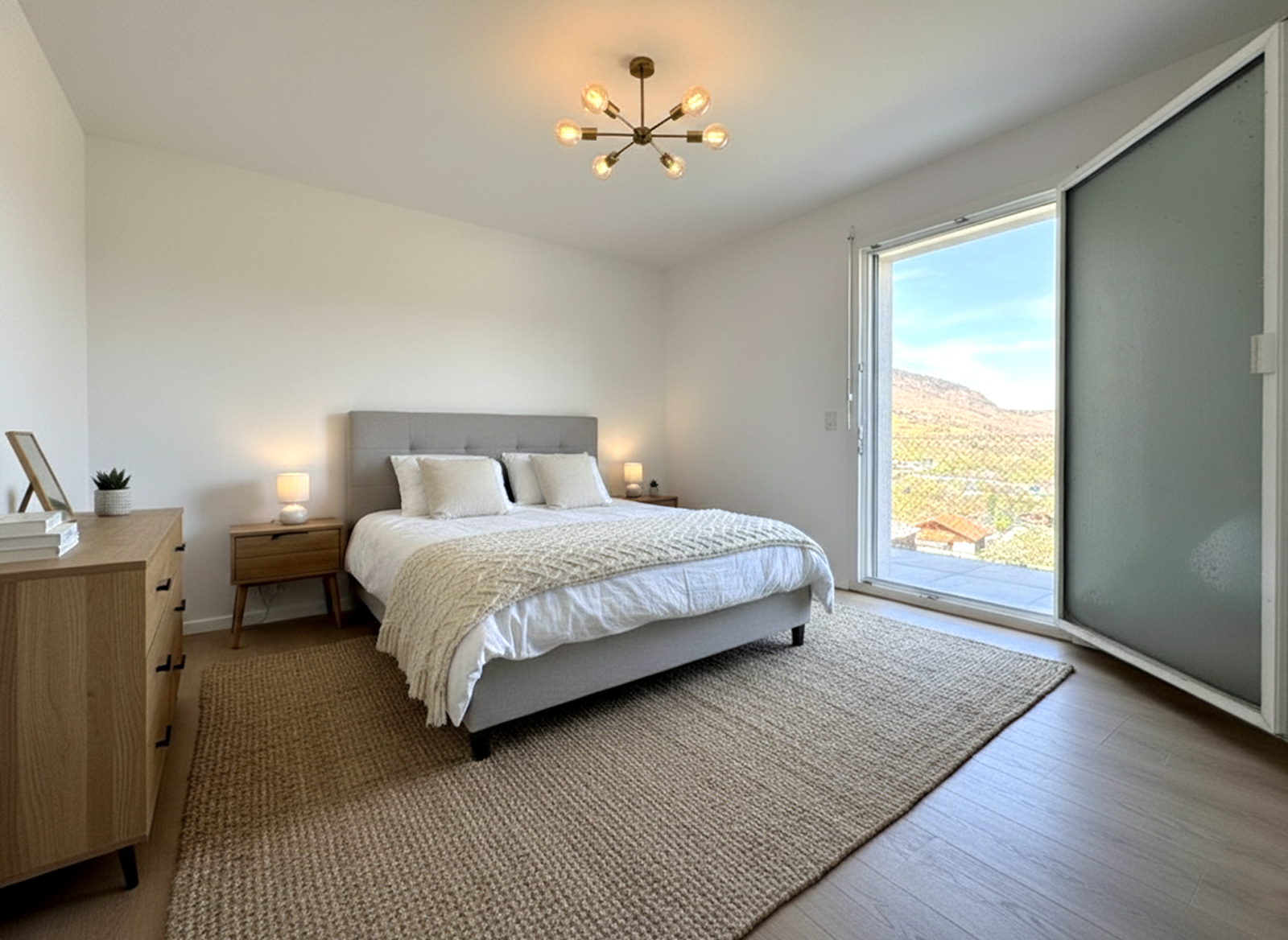 Helles Schlafzimmer mit großem Fenster und Balkonblick
