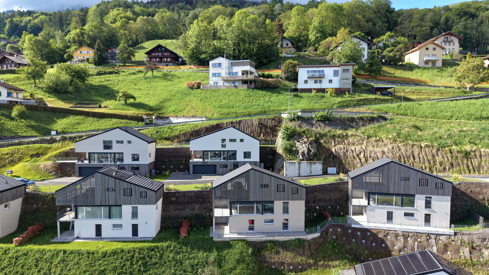 Häuser in Hanglage mit Berg- und Talblick