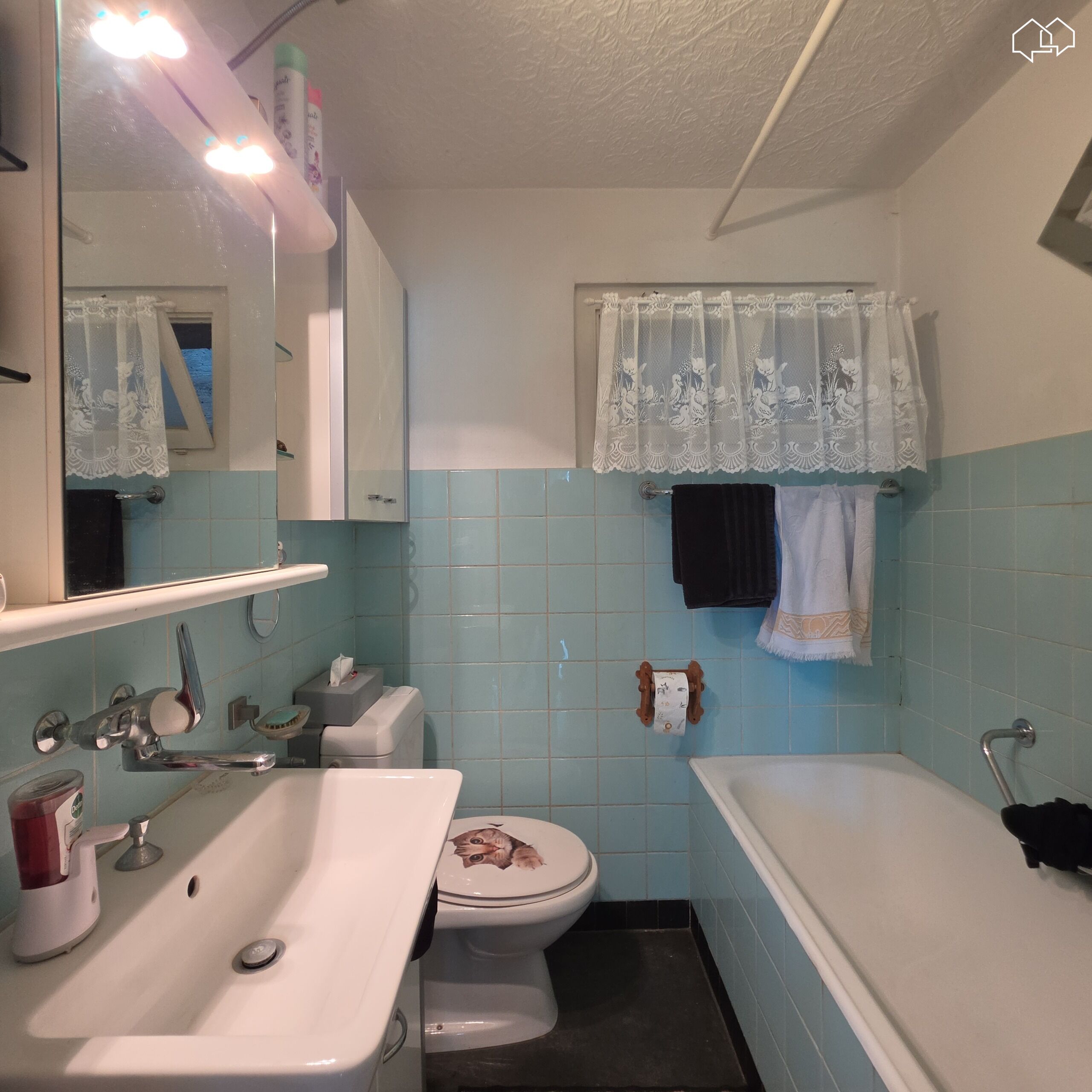 Kleines Badezimmer mit Badewanne und Waschbecken