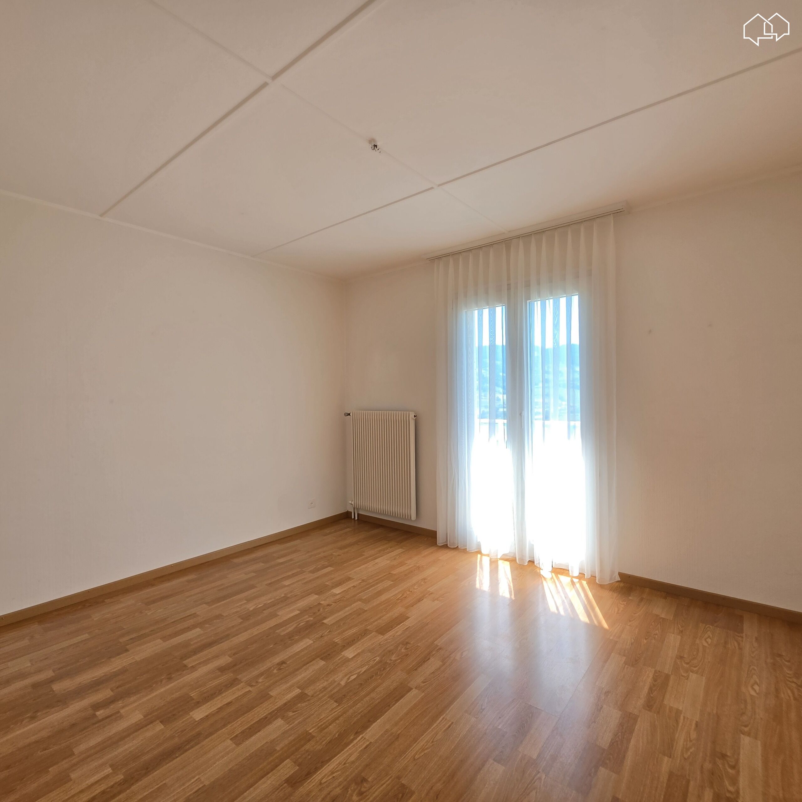 Leerer, heller Raum mit Holzparkett