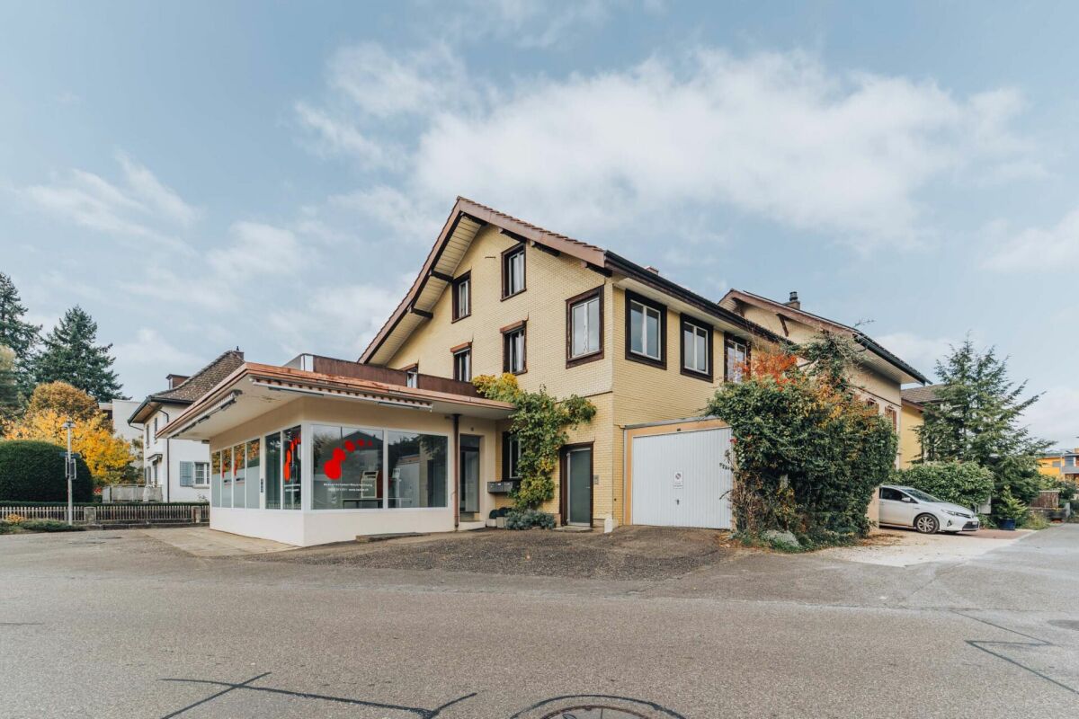 Außenansicht eines Wohn- und Geschäftshauses mit Carport/Anbau