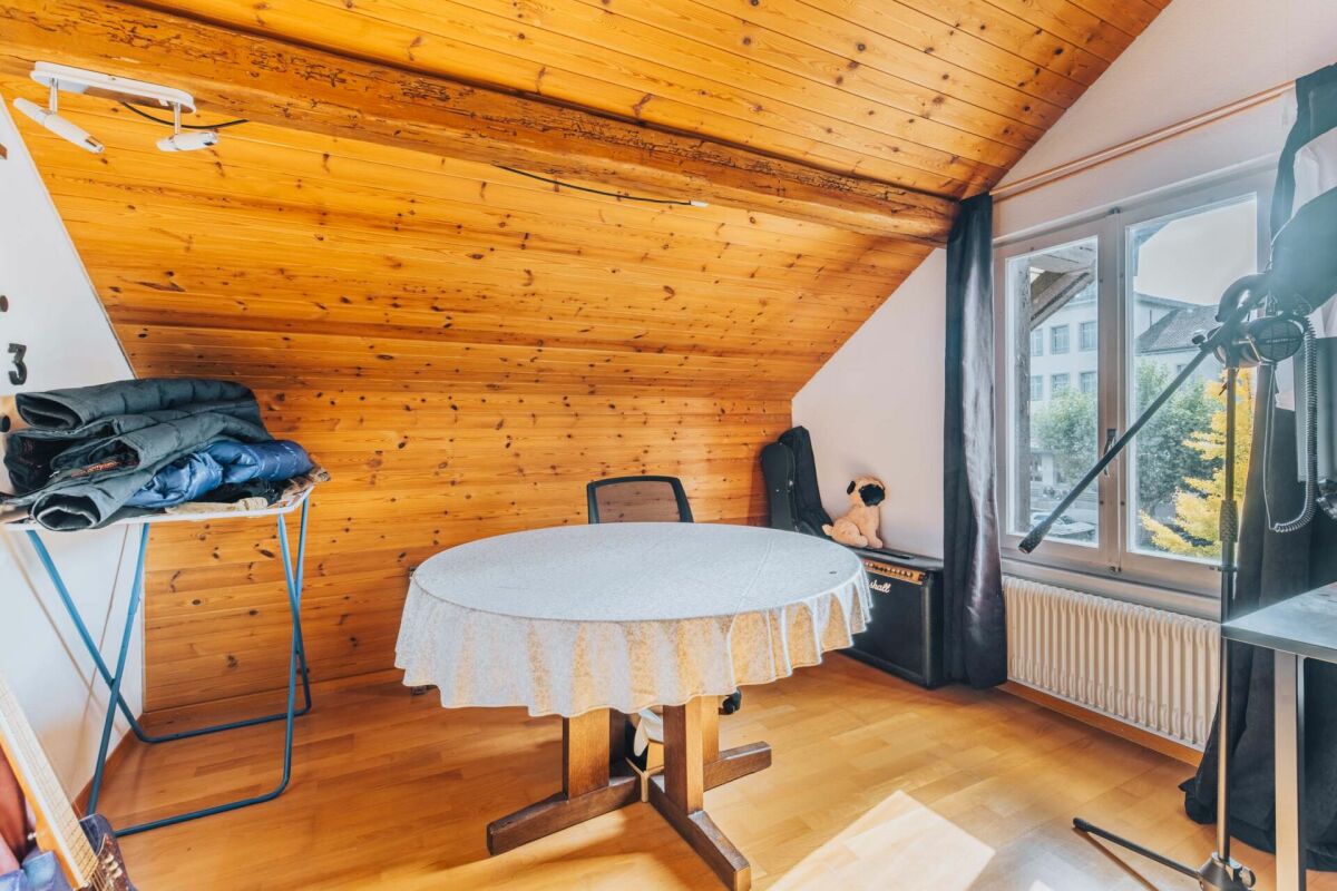 Dachzimmer mit Holzdecke und Fenster