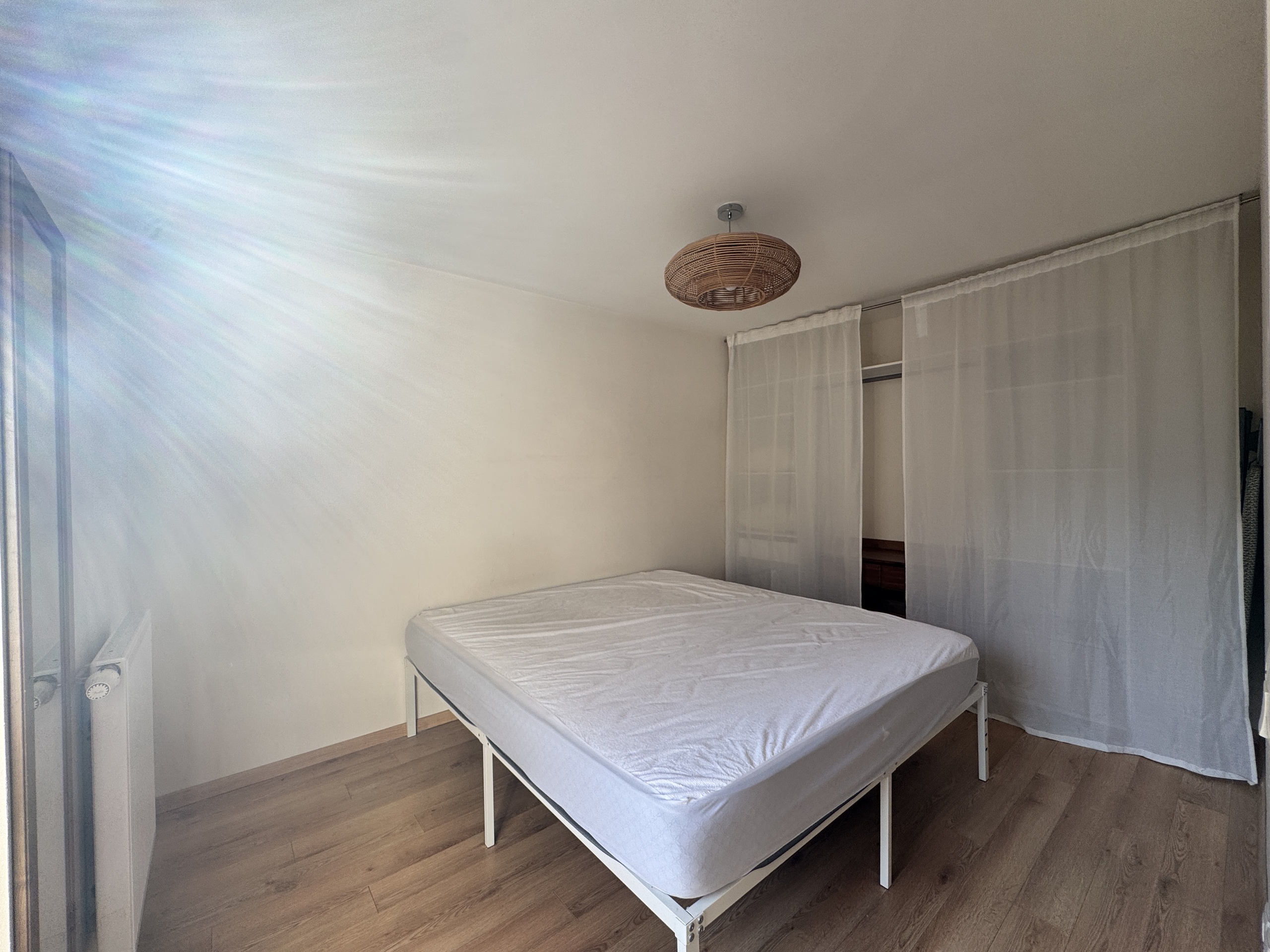 Helles Schlafzimmer mit Bett und Kleiderschrank