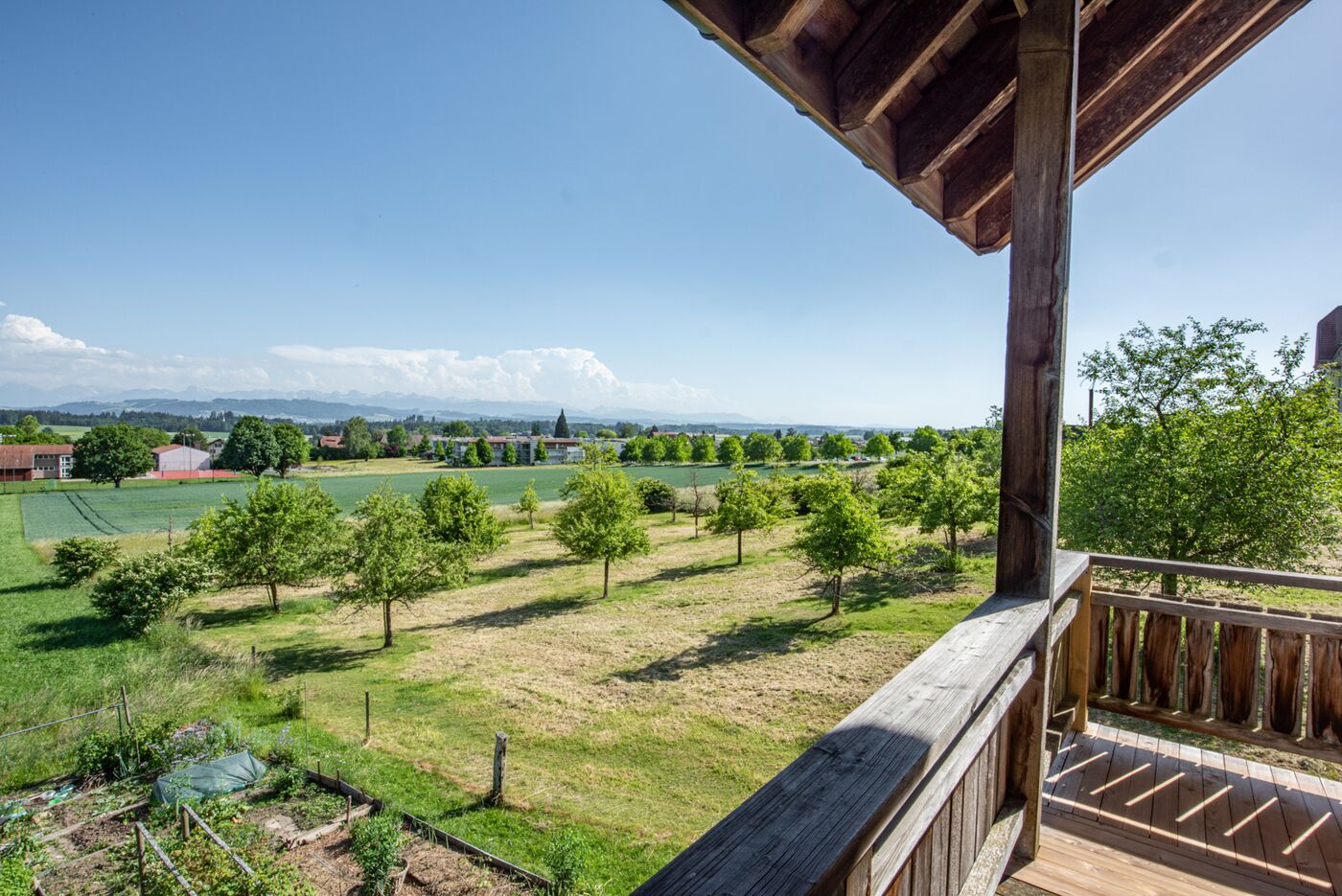 Blick von einer Holzterrasse in die grüne Landschaft