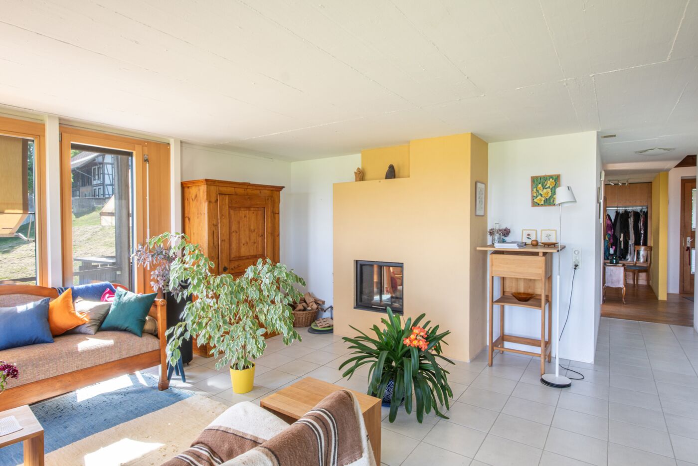 Heller Wohnbereich mit Kamin und Blick ins Grün