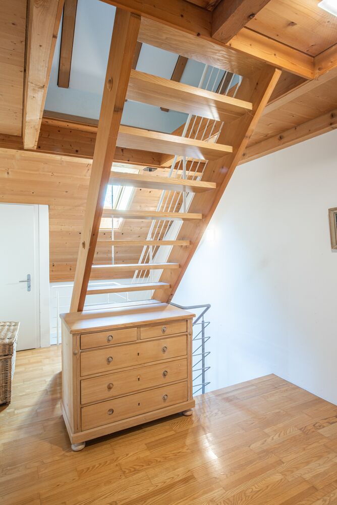 Treppenaufgang mit Holztreppe und Kommode