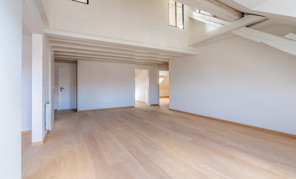 Heller Dachgeschossraum mit sichtbaren Holzbalken