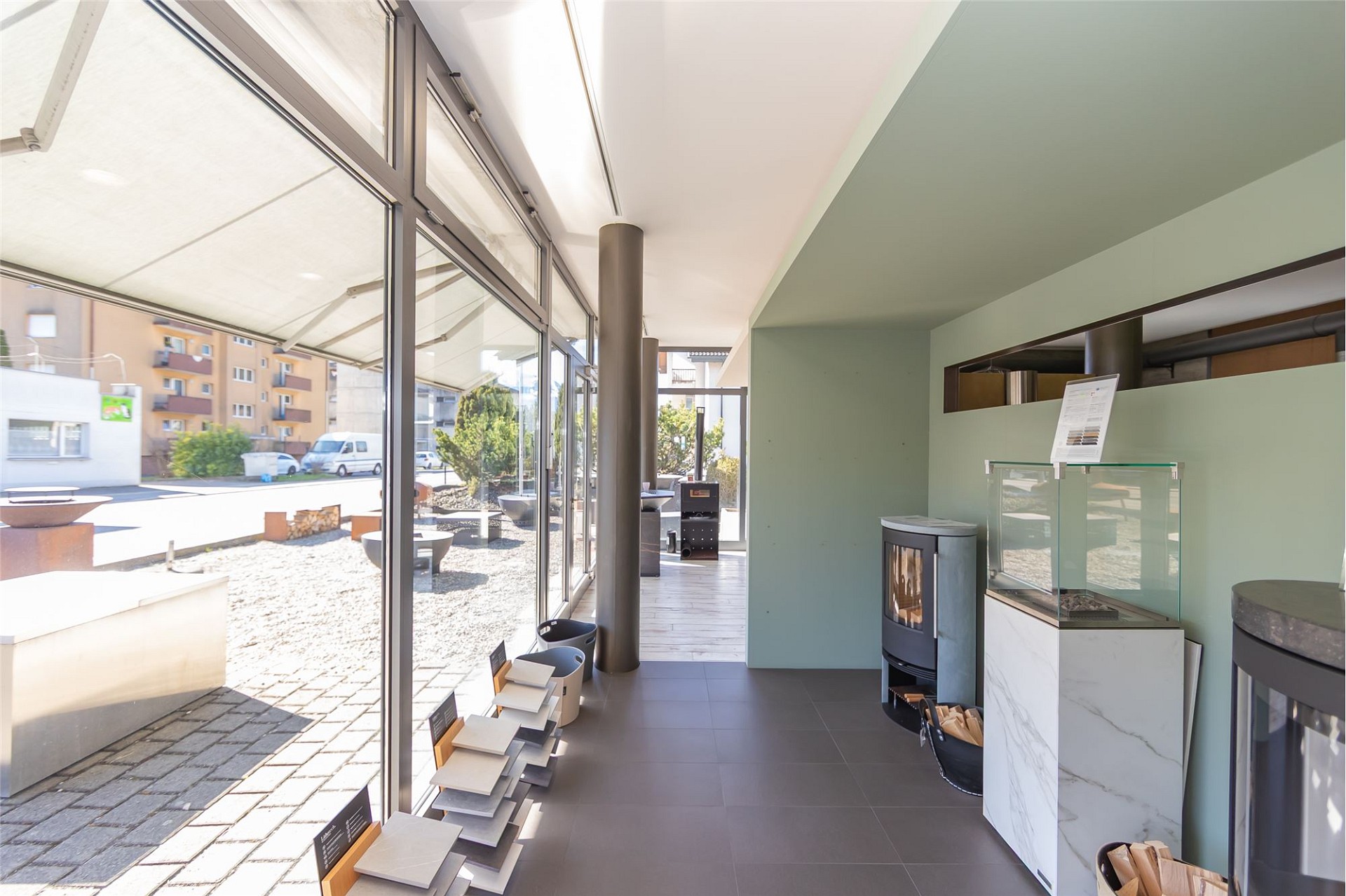 Moderner Ausstellungsraum mit Glasfront und Kaminofen