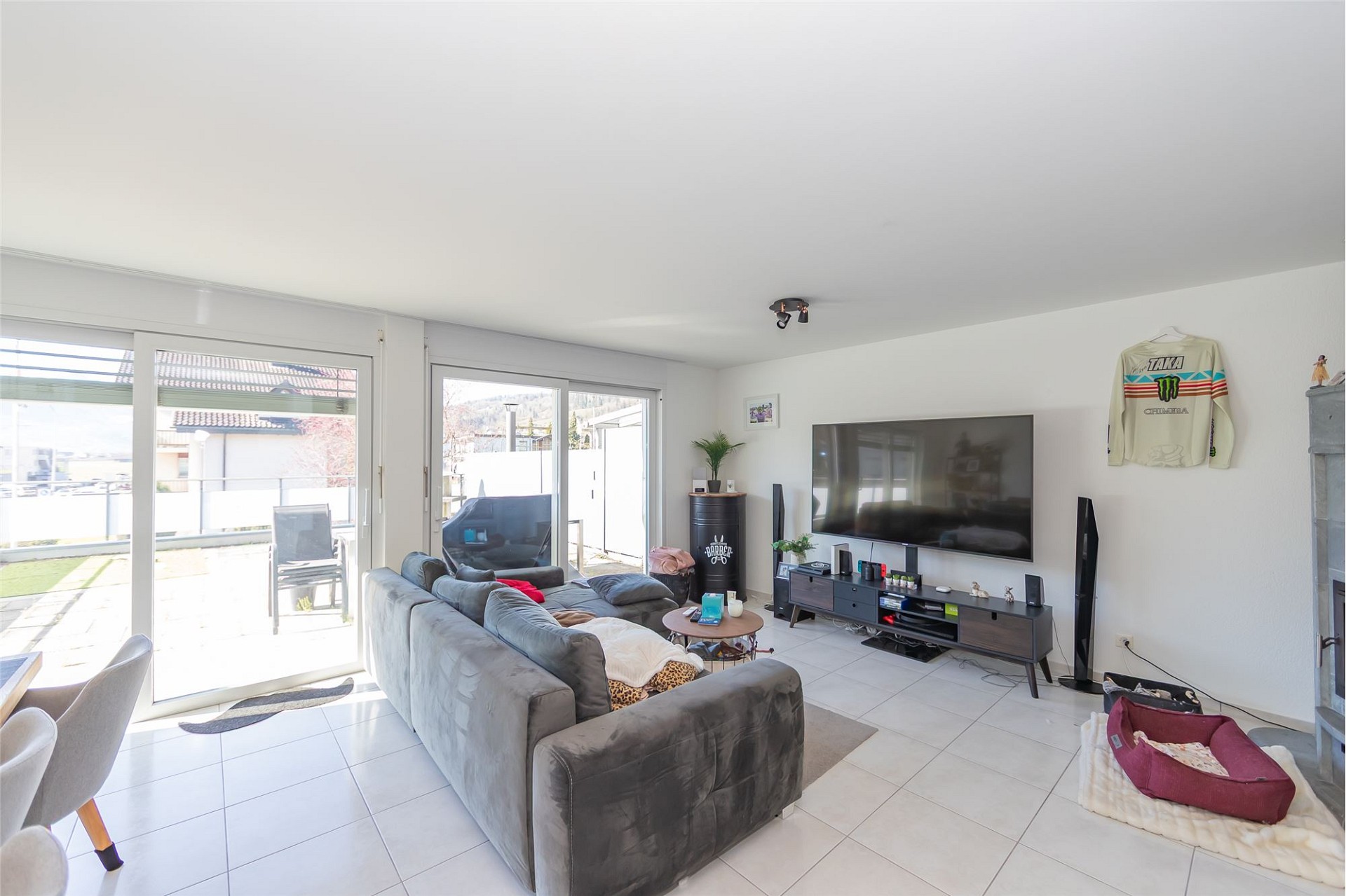 Helles Wohnzimmer mit Terrasse und TV-Wand