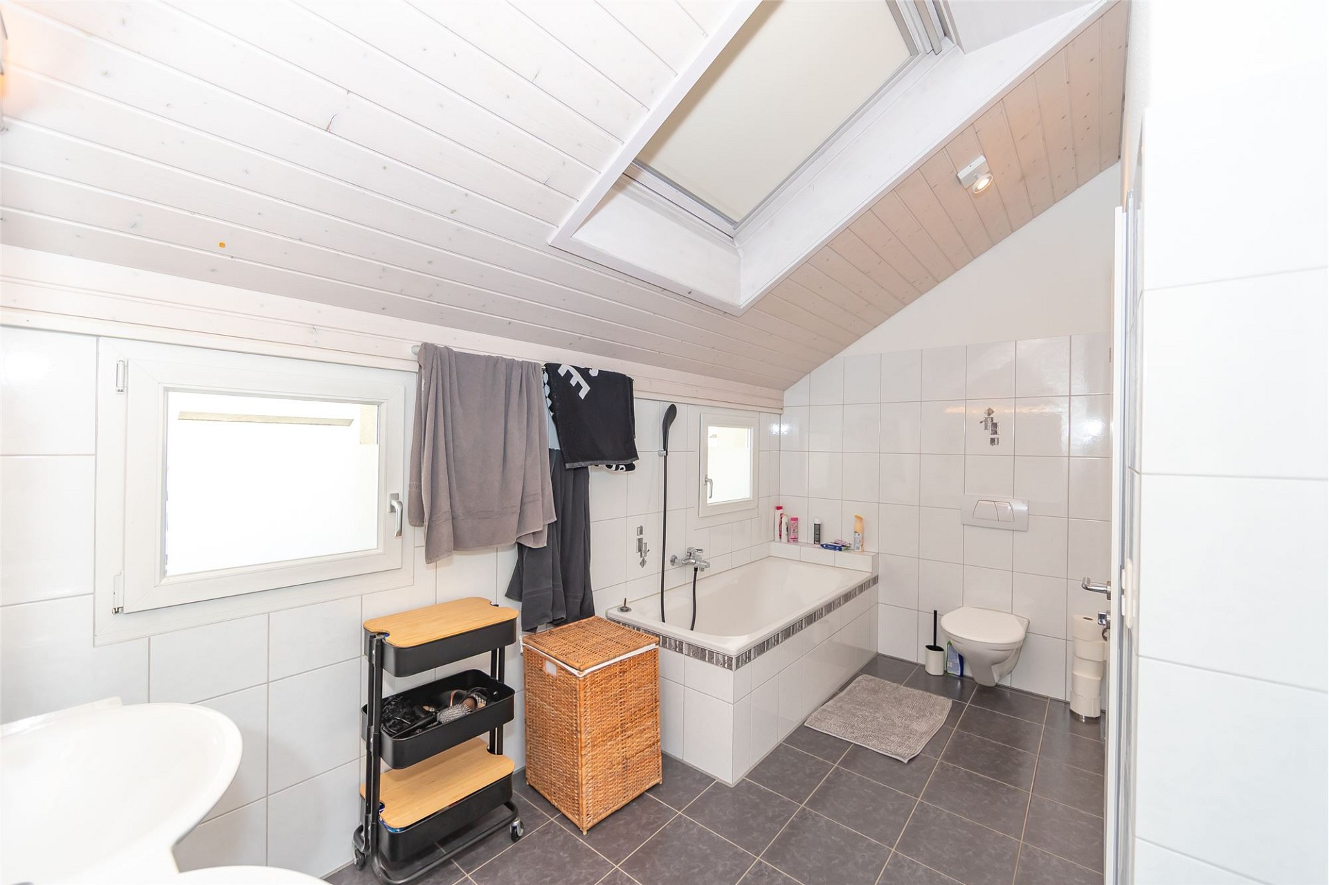 Dachgeschoss-Badezimmer mit Badewanne und WC