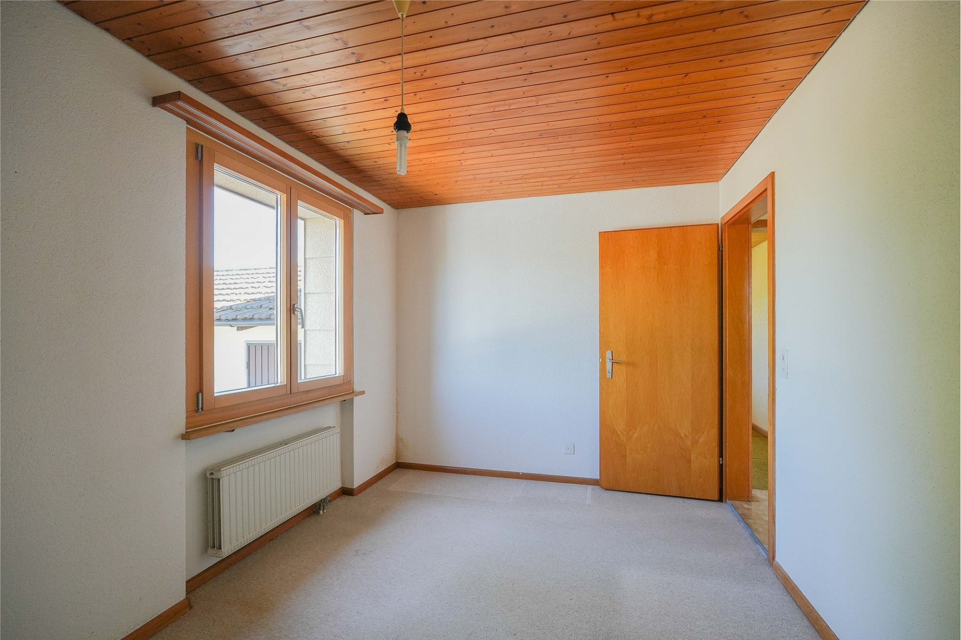 Helles, leeres Zimmer mit Holzdecke