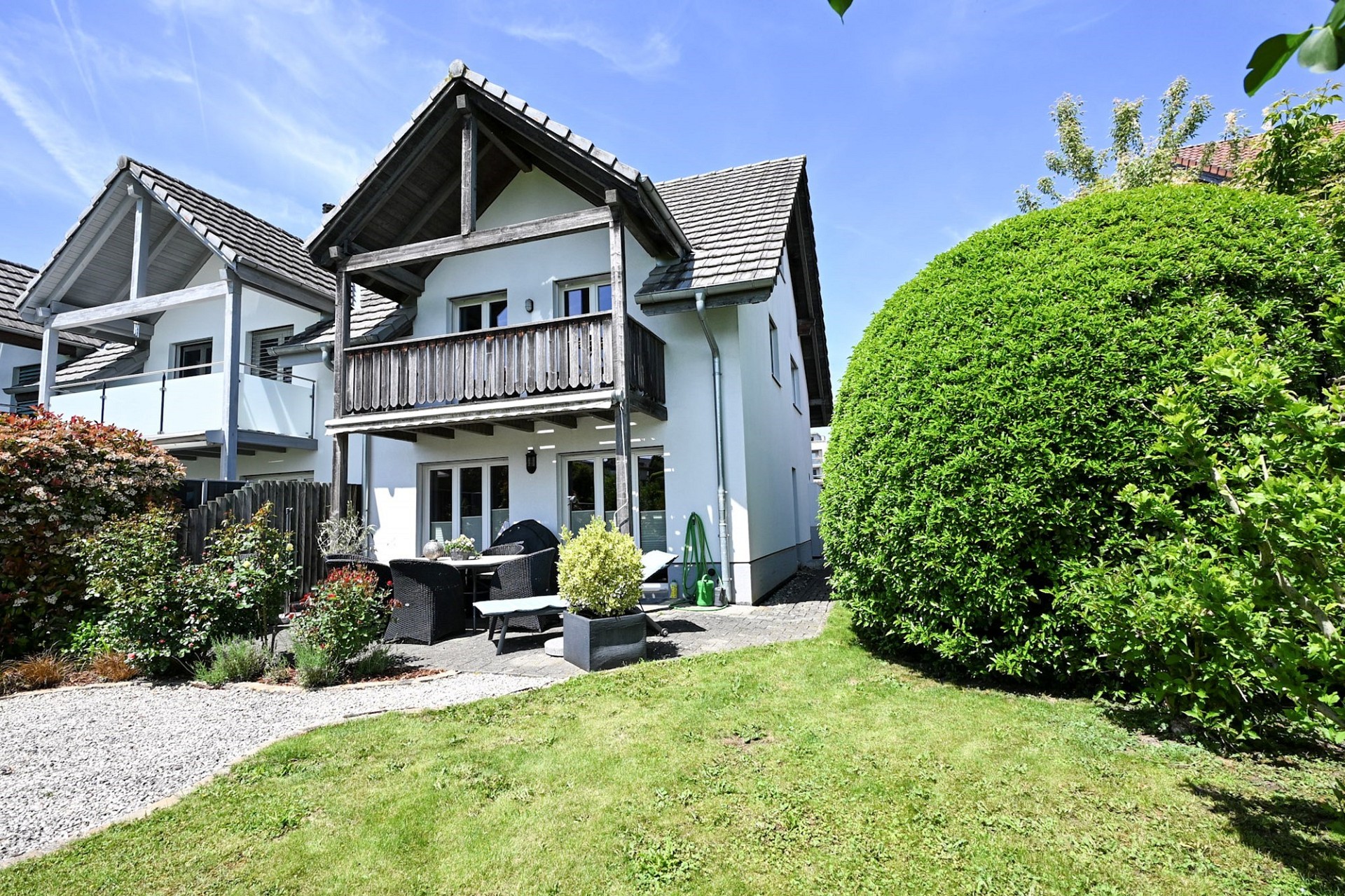 Außenansicht eines Einfamilienhauses mit Garten und Terrasse