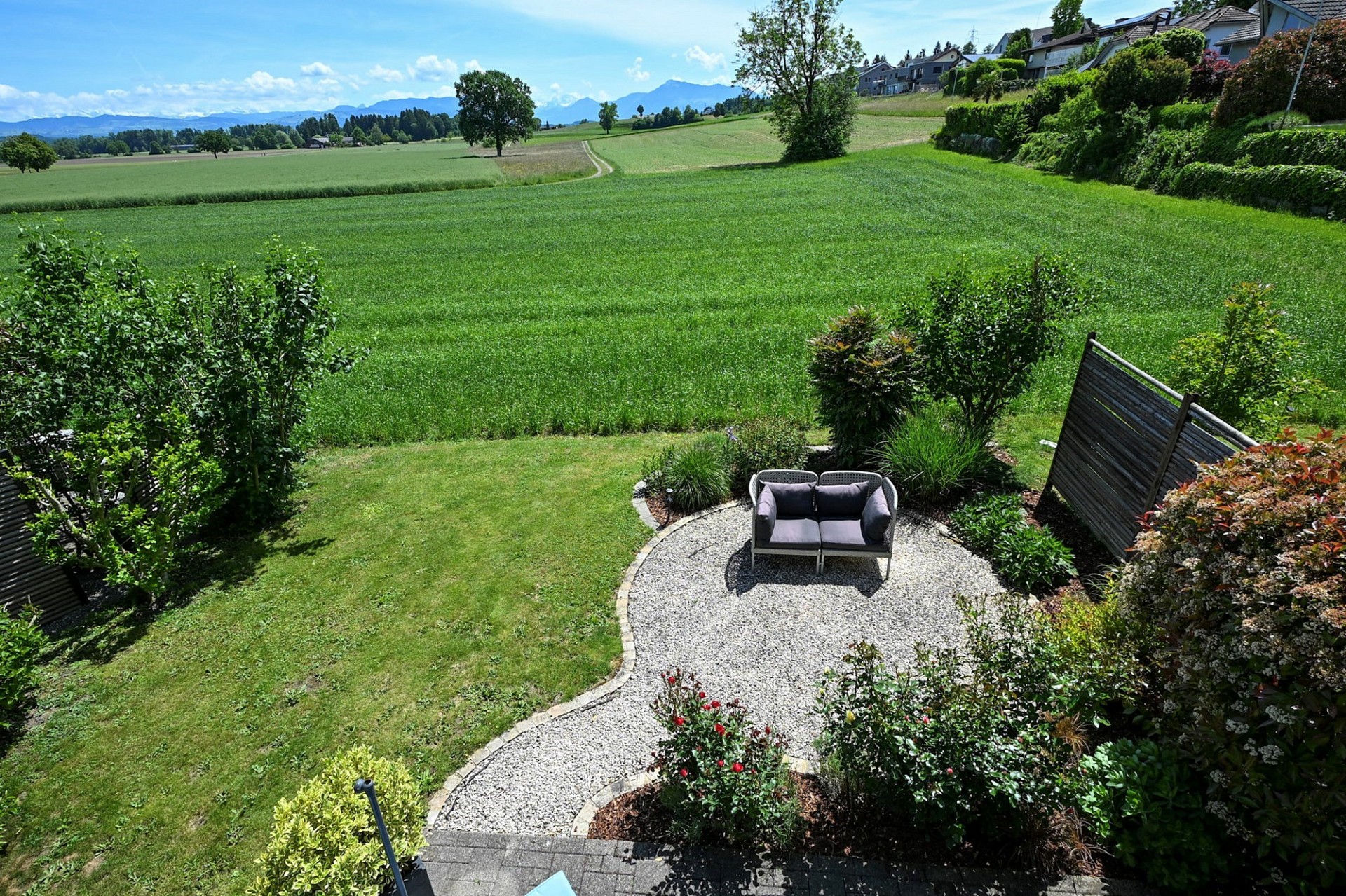 Gepflegter Garten mit Terrassenbereich und weiter Landschaftssicht