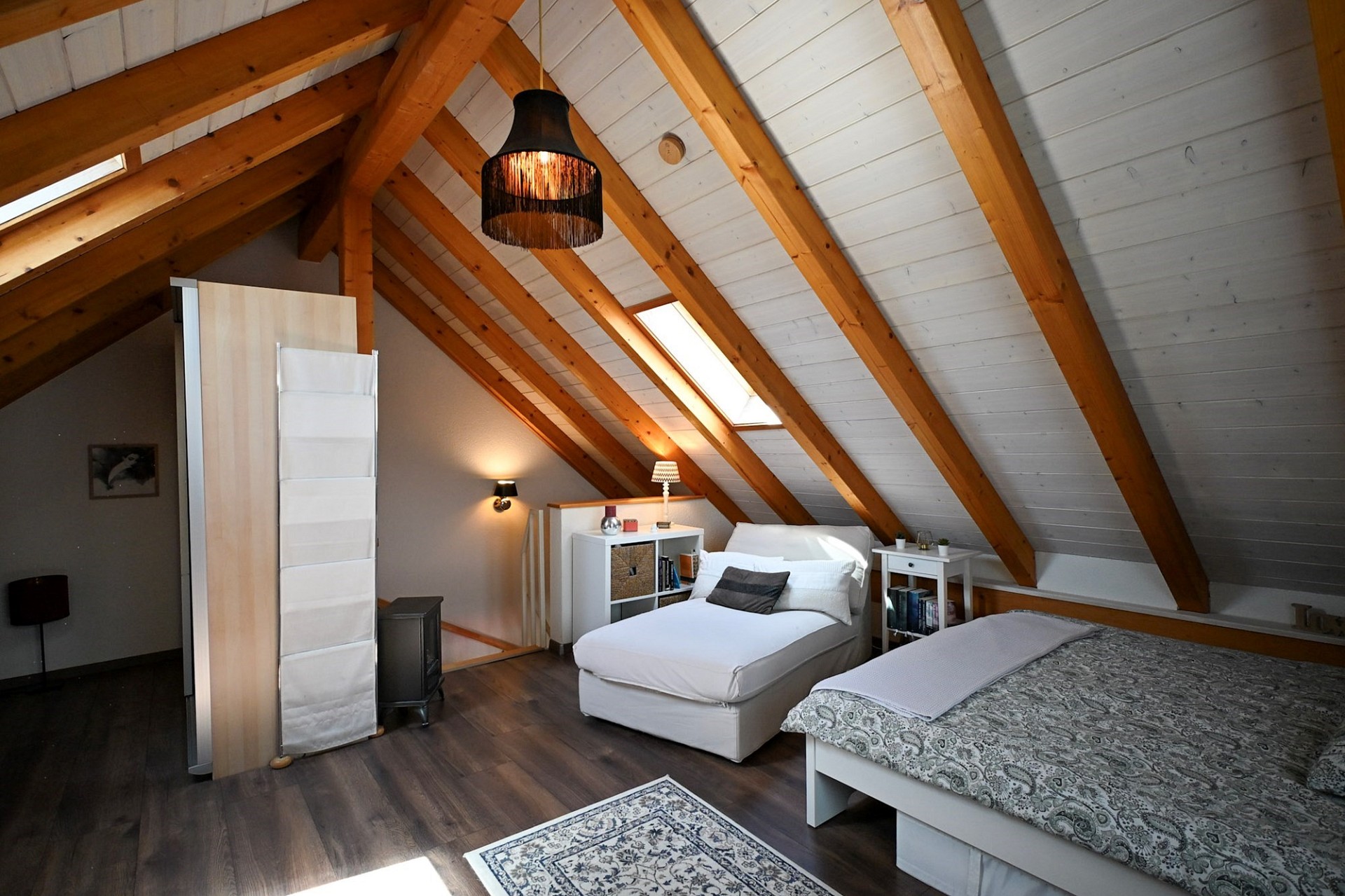 Dachgeschoss-Schlafzimmer mit sichtbaren Holzbalken