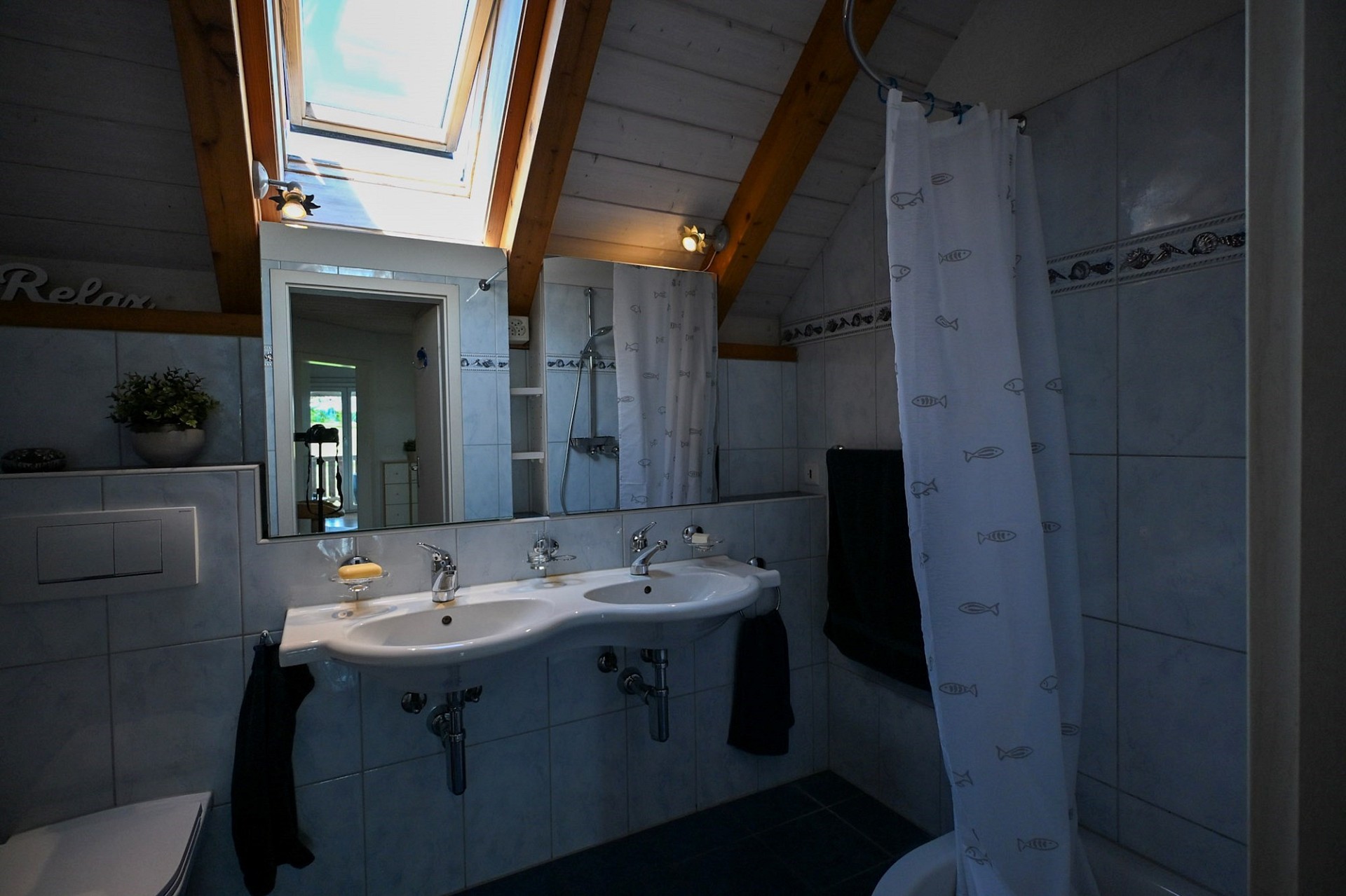 Badezimmer mit Dachfenster und Doppelwaschbecken
