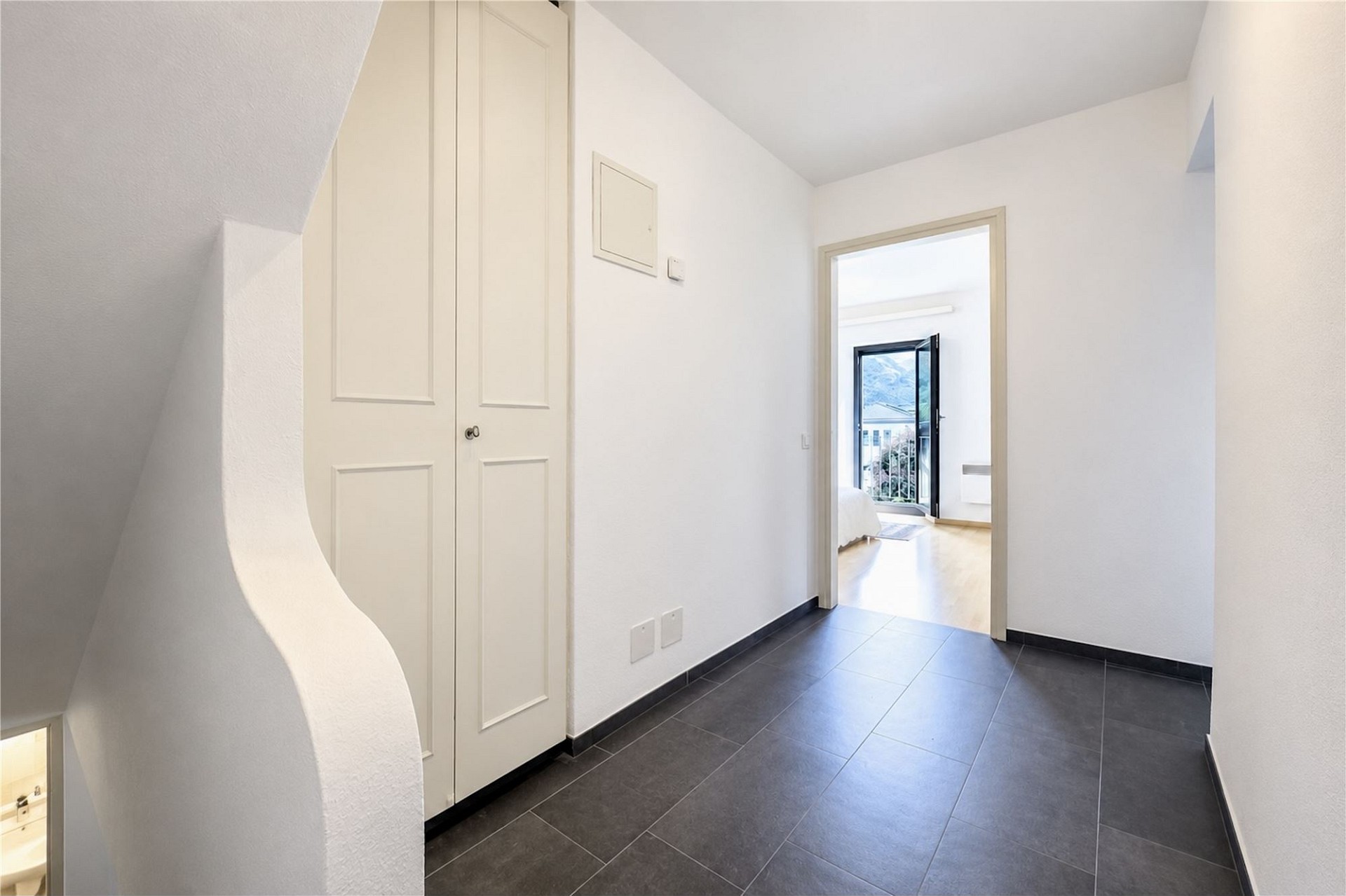 Heller Flur mit Treppe und Blick in einen angrenzenden Raum