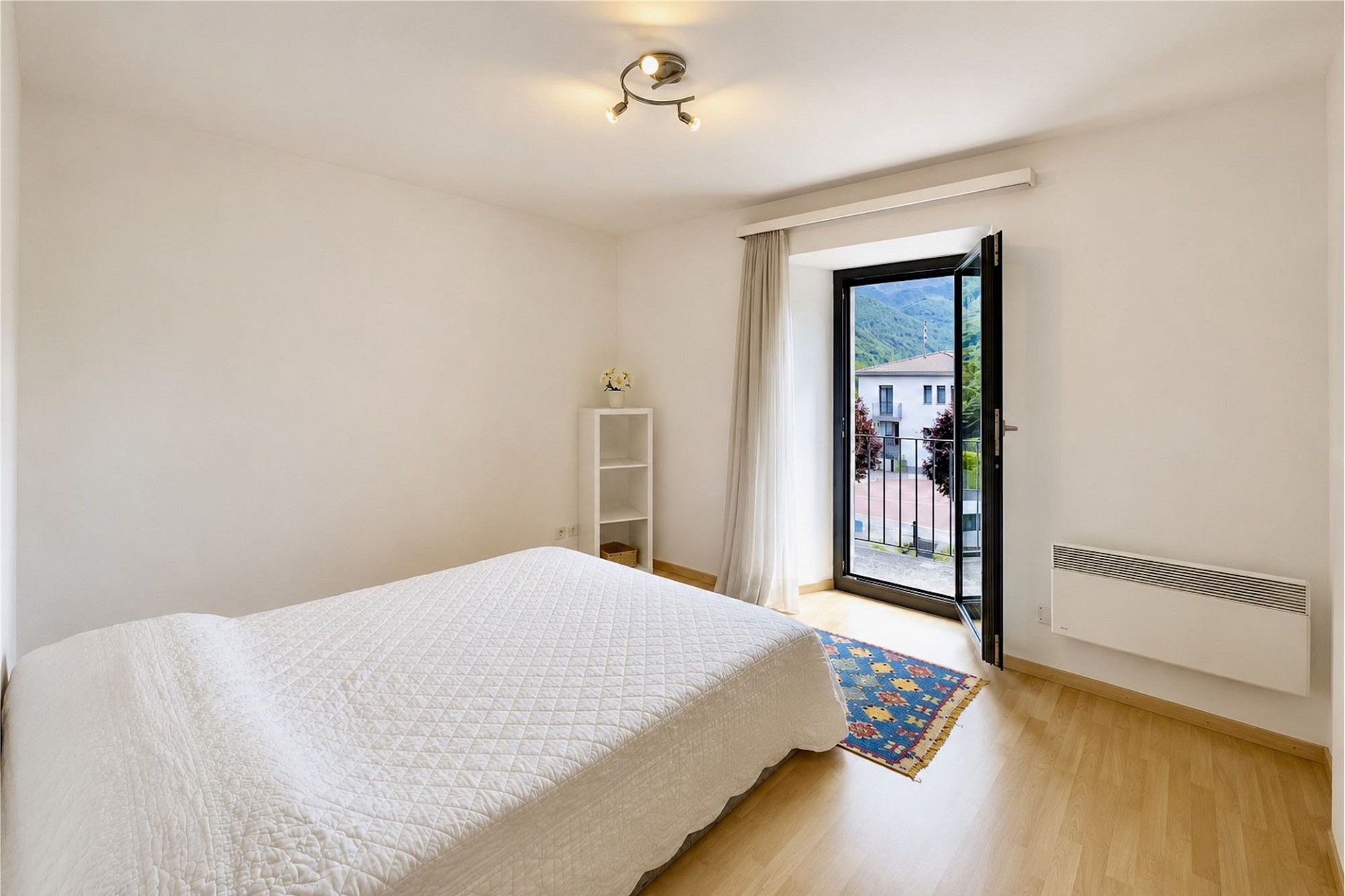 Helles Schlafzimmer mit Balkon und Bergblick