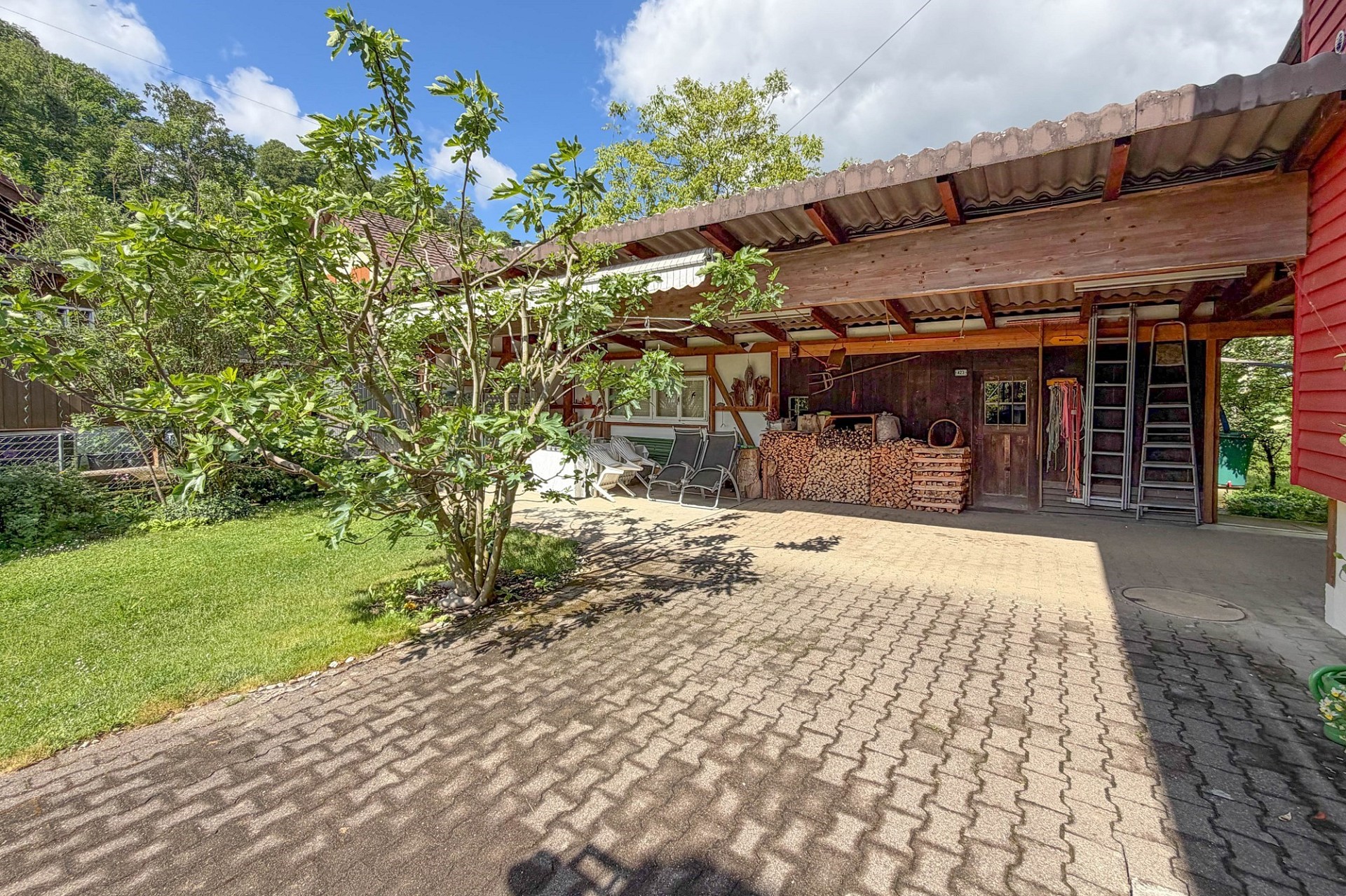 Überdachter Außenbereich mit Garten und Holzunterstand