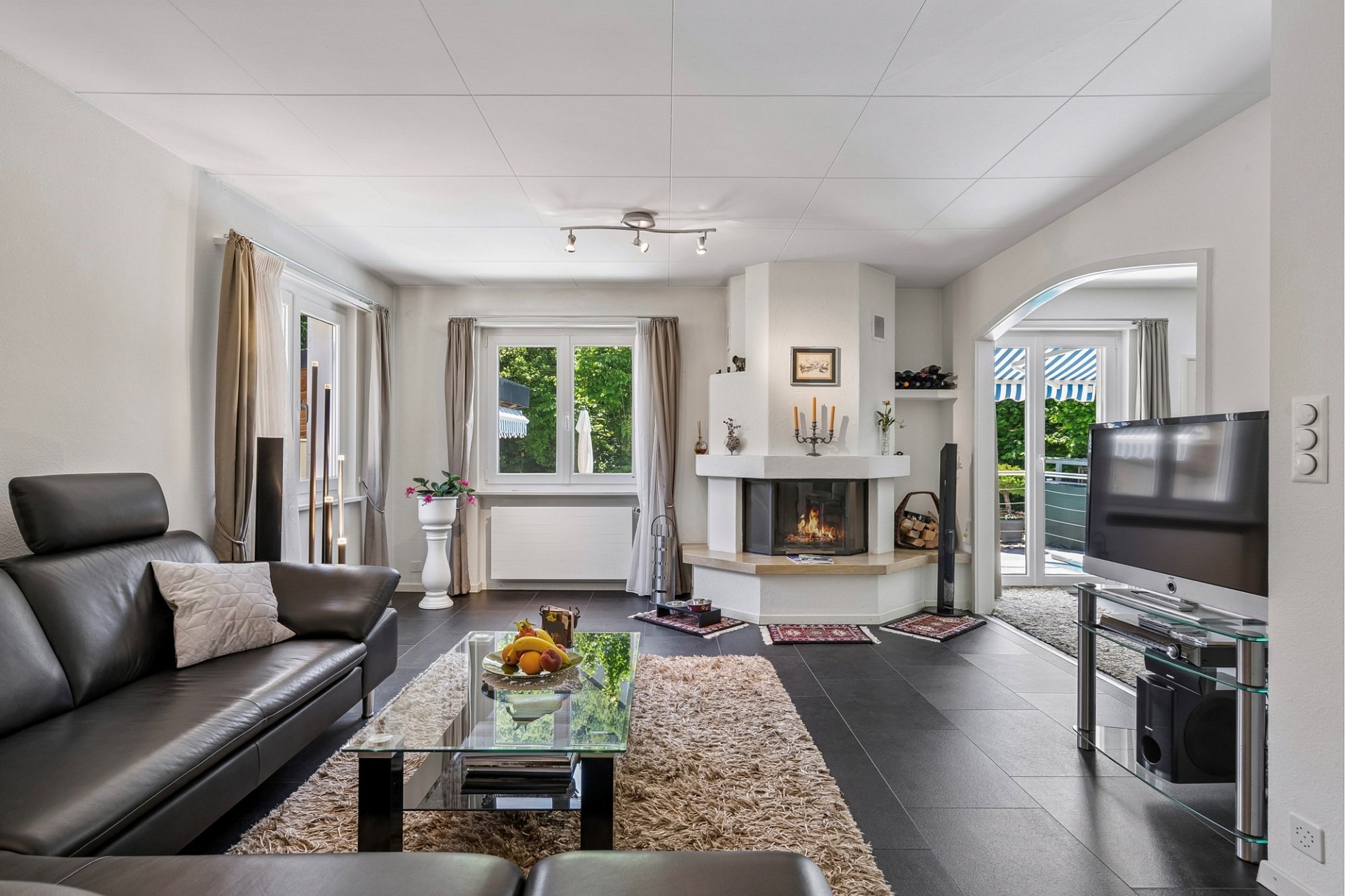 Heller Wohnraum mit Kamin und Zugang zur Terrasse