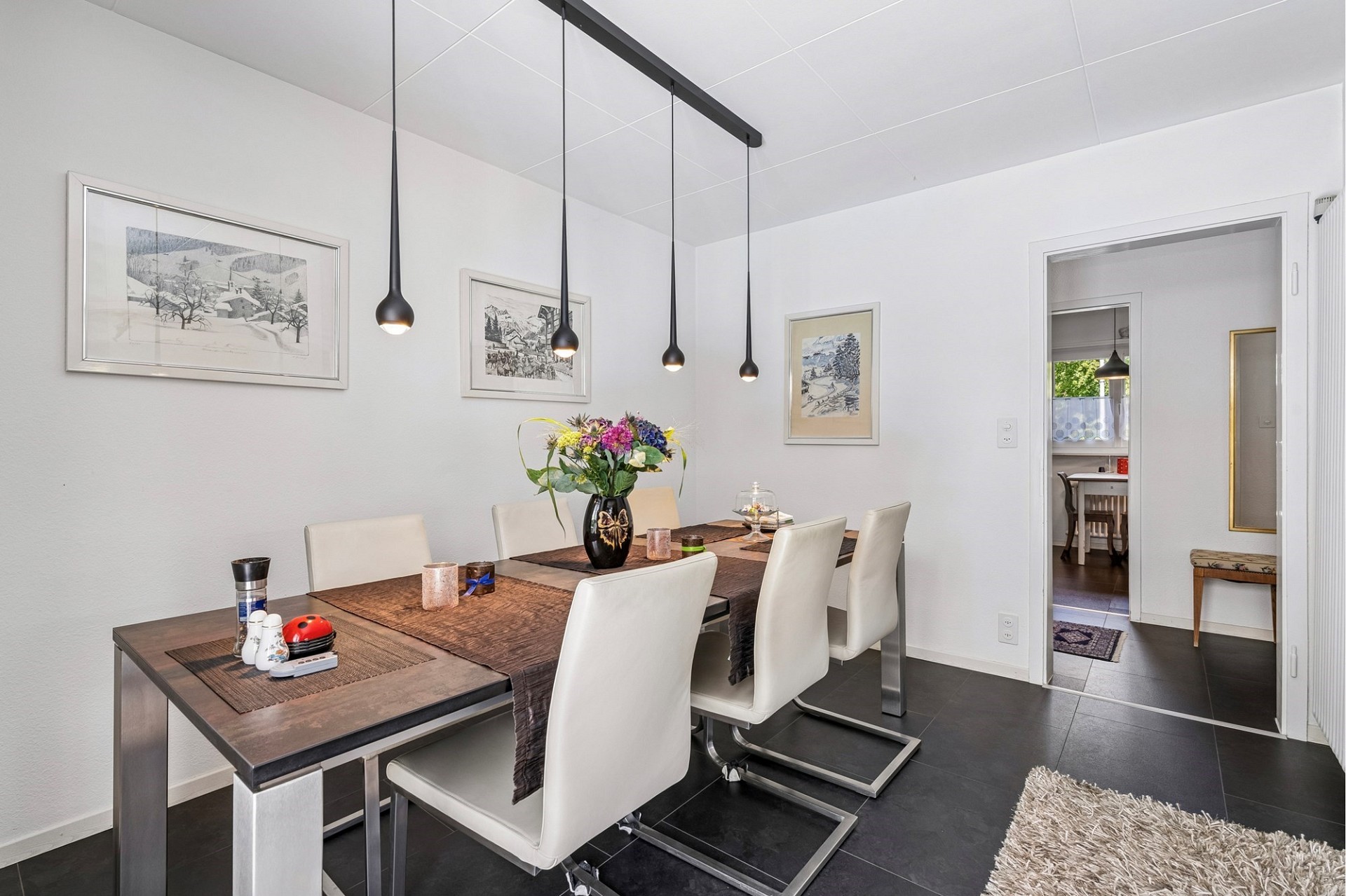 Esszimmer mit modernem Tisch und Pendelleuchten