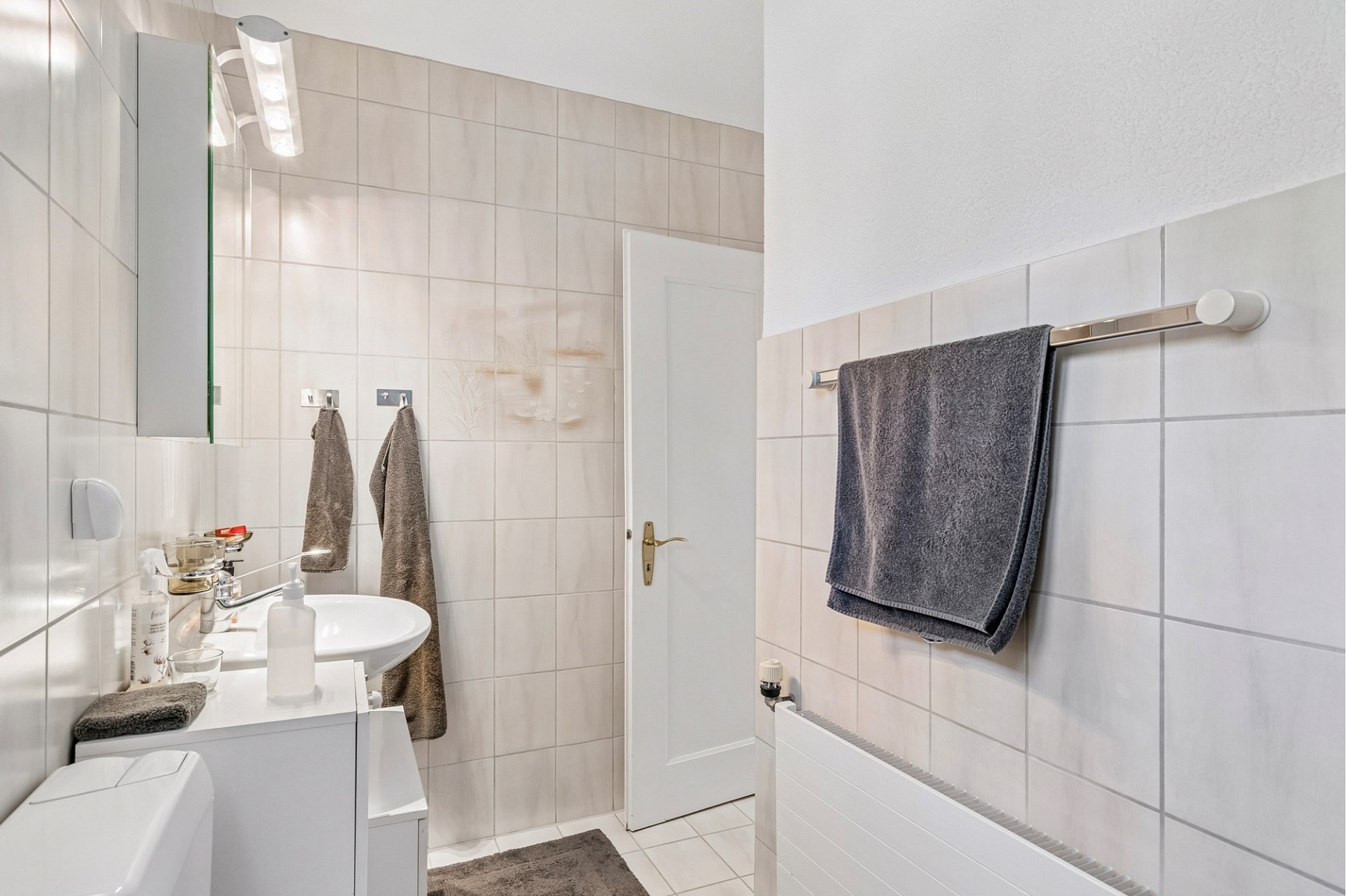 Helles Badezimmer mit heller Fliesenverkleidung