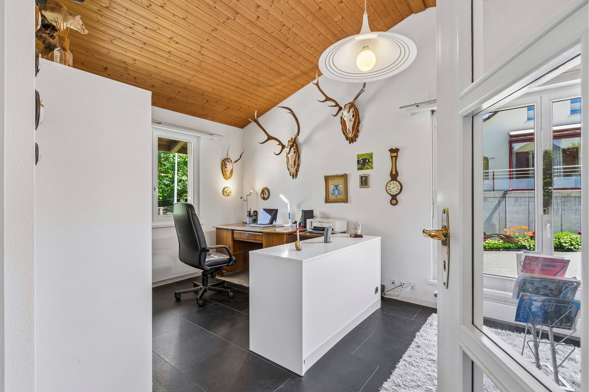 Helles Büro mit Holzdecke und Jagddekor