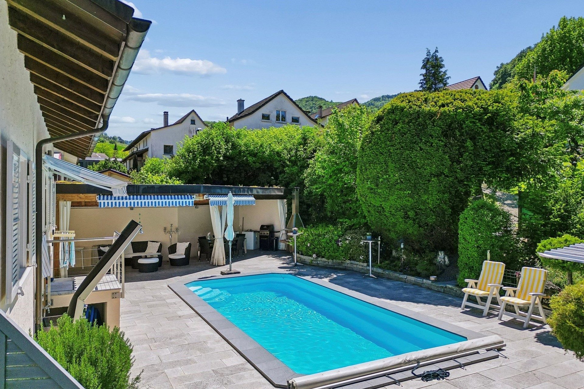 Außenbereich mit Pool und Gartenlounge
