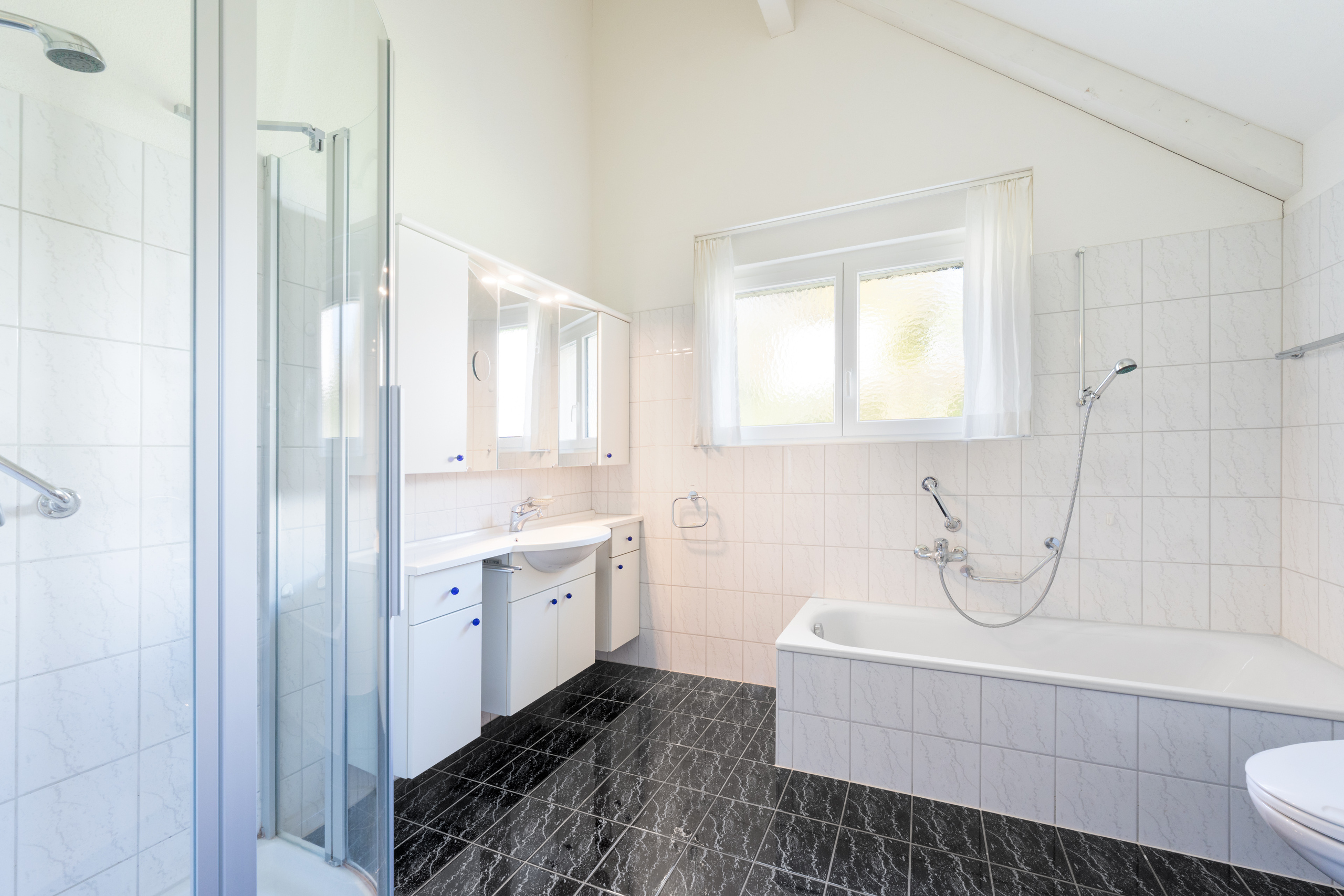 Helles Badezimmer mit Dusche, Wanne und Dachschräge