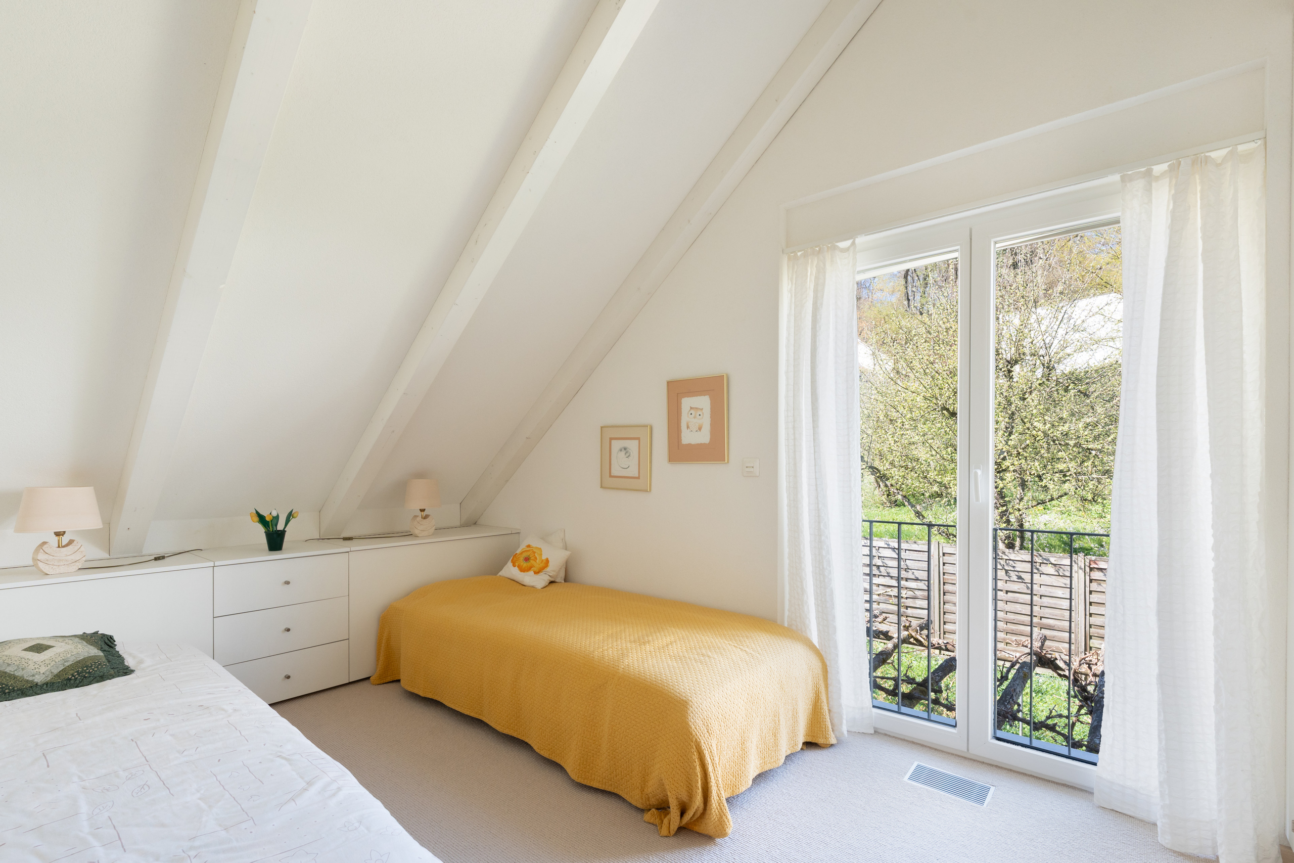 Helles Dachgeschoss-Schlafzimmer mit Balkonblick