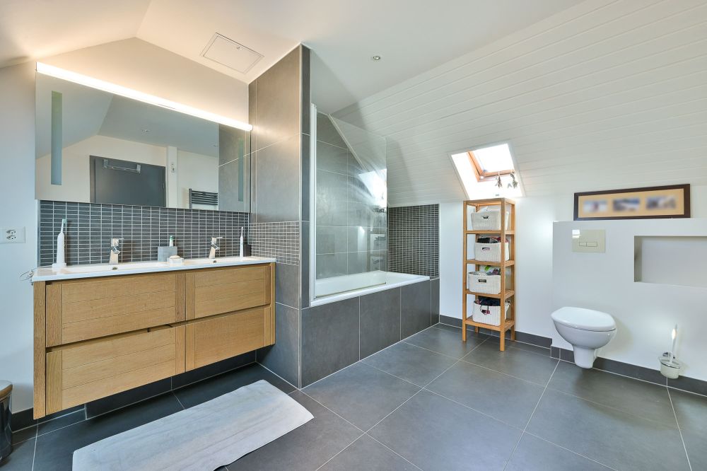 Modernes Dachbad mit Badewanne, Waschtisch und WC