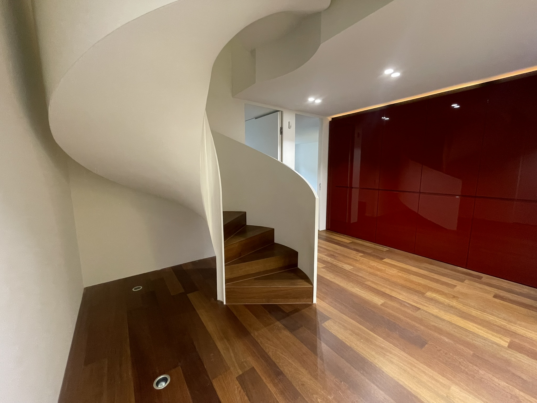 Moderne Diele mit gewendelter Treppe und Hochglanz-Einbauten