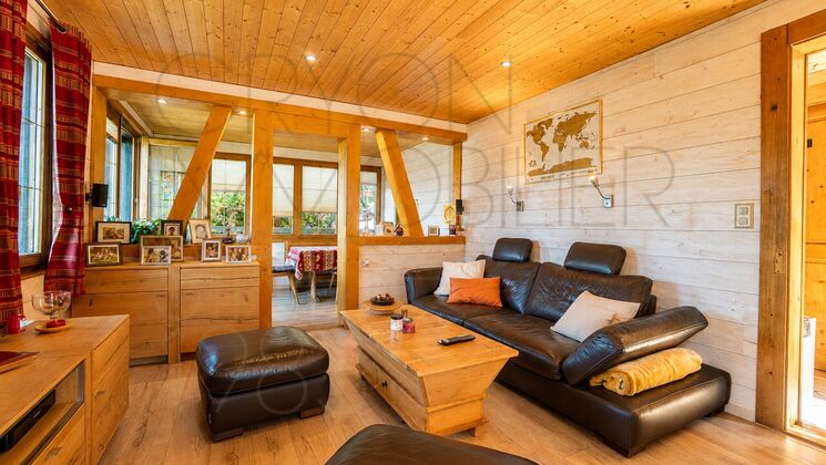 Gemütliches Holzwohnzimmer mit dunkler Ledergarnitur