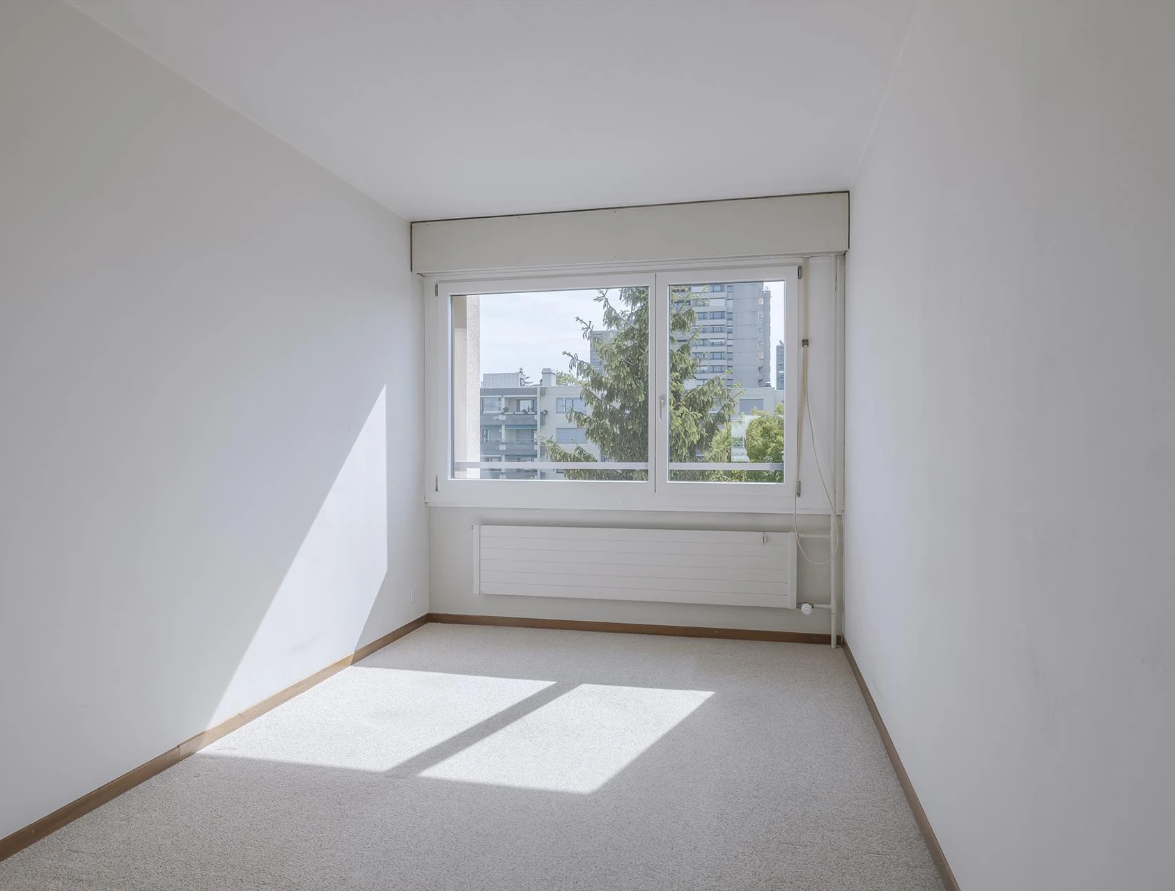 Helles, leeres Zimmer mit Fensterfront