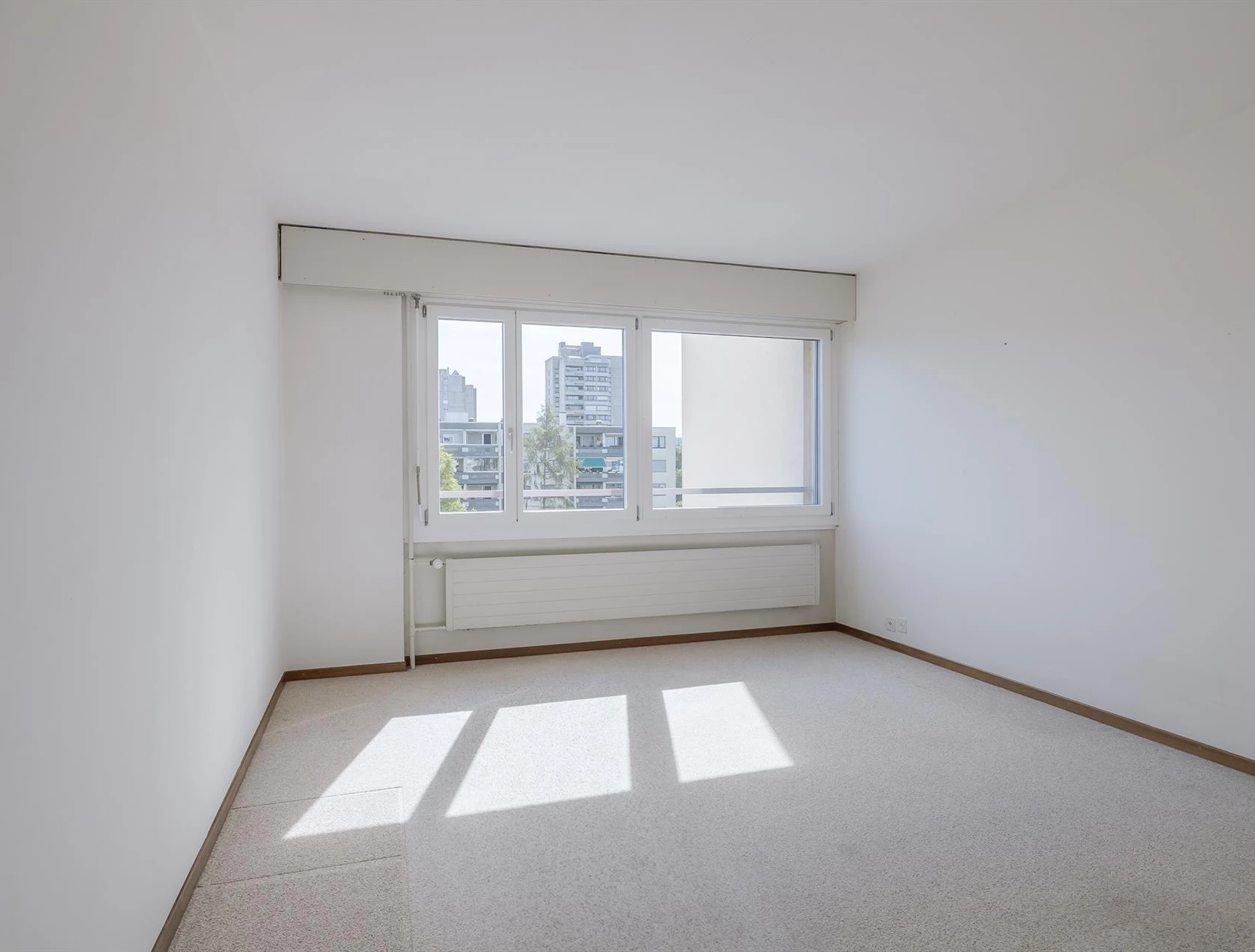 Heller leerer Wohnraum mit Fensterfront
