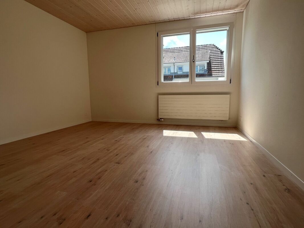 Leeres helles Zimmer mit Holzoptik-Boden