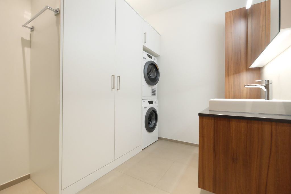 Hauswirtschaftsraum mit Waschturm und Einbauschrank