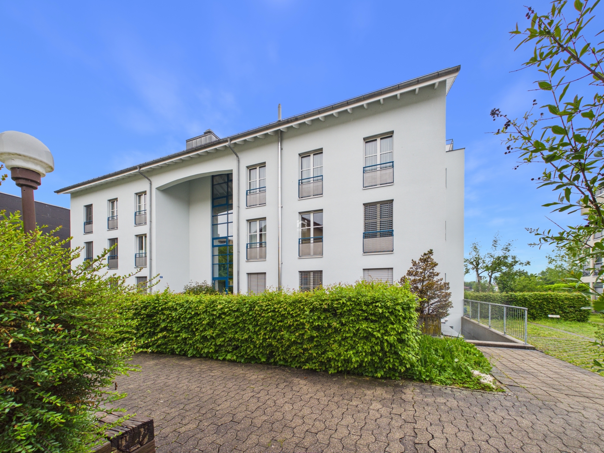 Mehrfamilienhaus mit weißer Fassade und Pultdach