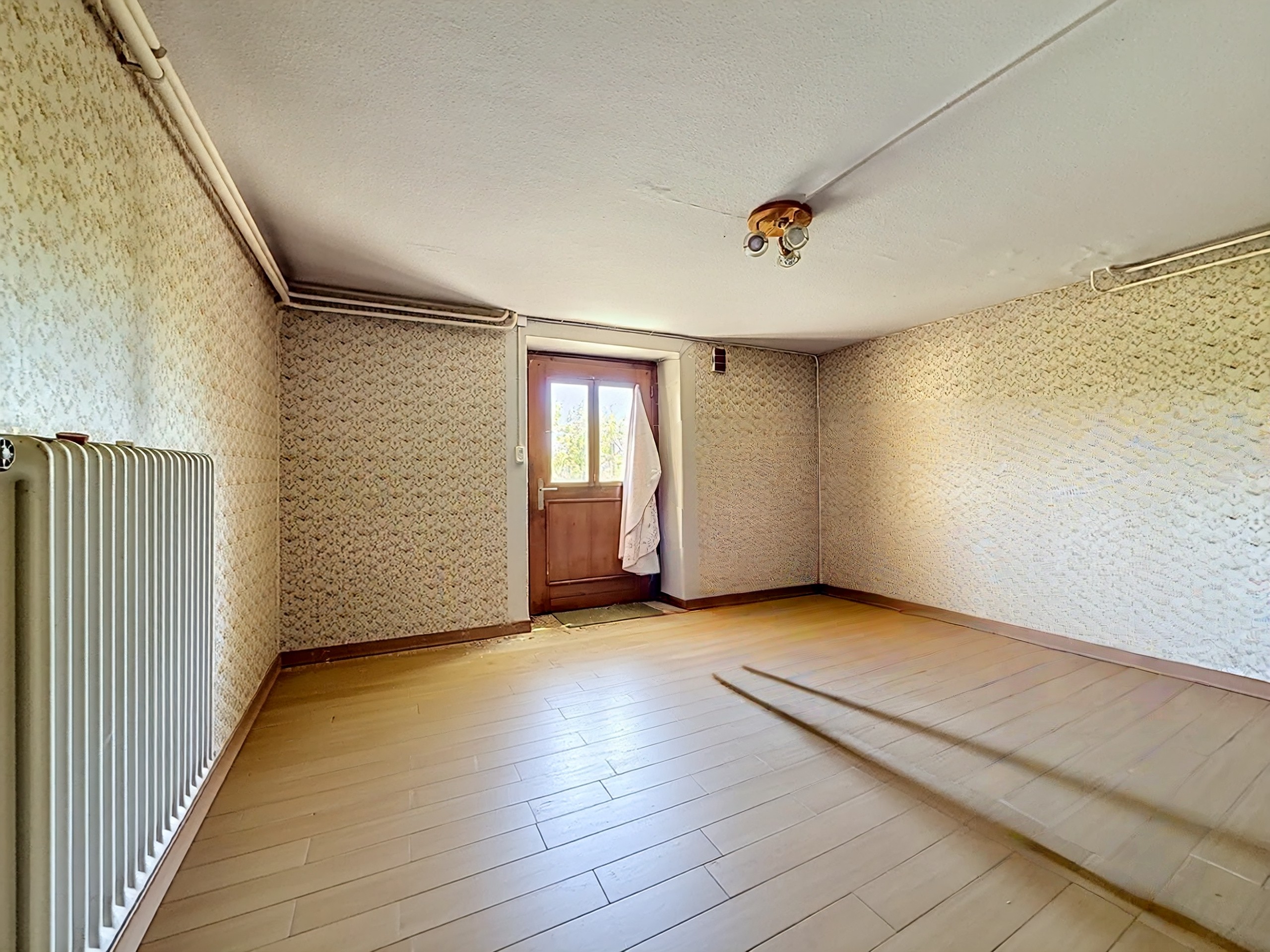 Leerer Innenraum mit Holztür und Heizkörper