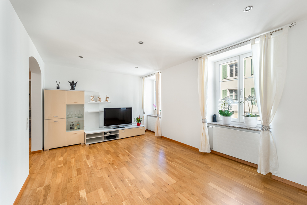 Heller Wohnraum mit Holzboden und TV-Wand
